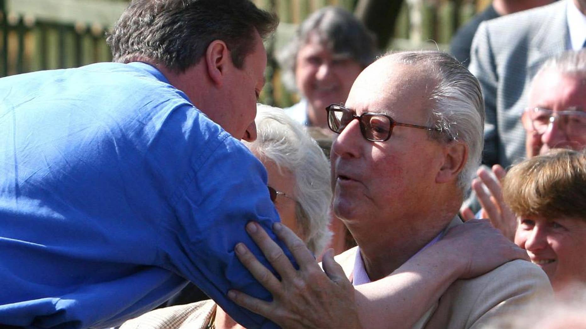 FILE - This is a March 18, 2010 file photo of Britain's Prime Minister David Cameron, left, as he greets his father Ian Cameron, in Swindon England. British Prime Minister David Cameron was under pressure Tuesday April 4, 2016 to crack down on offshore tax havens, after a leak of millions of documents disclosed details of the asset-hiding arrangements of wealthy people including his late father. The Guardian newspaper revealed in 2012 that Ian Cameron, who died in 2010, used a Panamanian fund and other offshore investments to help shield investments from U.K. tax. (Johnny Green/PA, File via AP) UNITED KINGDOM OUT