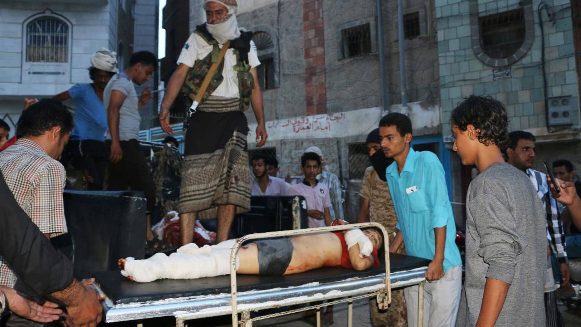 Tribal fighters, against Shiite rebels known as Houthis, carry a boy who was killed during fighting between the two groups, in Taiz, Yemen, Tuesday, Aug. 20, 2015. In Taiz, Yemen's third largest city, at least 11 civilians were killed and more than 35 injured by shelling that started on Wednesday, independent local officials, witnesses and medical officials said, speaking on condition of anonymity because they were not authorized to talk to reporters. They all said the shelling was by Houthi fighters who were attacking areas controlled by pro-government forces. (AP Photo/Abdulnasser Alseddik)