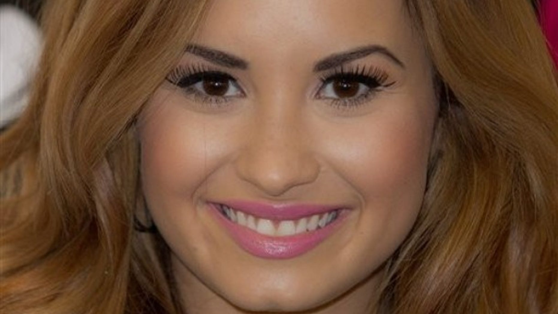 US singer Demi Lovato poses for photographs before she meets fans and signs copies of her new album, 'Unbroken', at a central London music store, Tuesday, April 3, 2012. (AP Photo/Joel Ryan)
