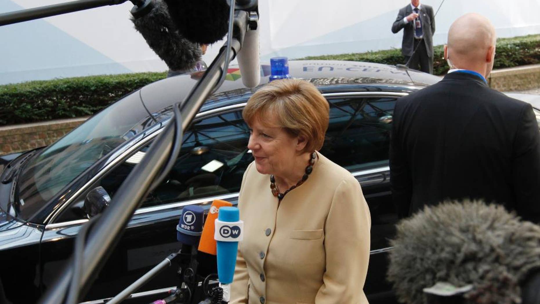 German Chancellor Angela Merkel, center, speaks with the media as she departs an EU-CELAC summit in Brussels on Thursday, June 11, 2015. The main aim of the Brussels summit was to boost trade and diplomatic ties with the region. (Geert Vanden Wijngaert)