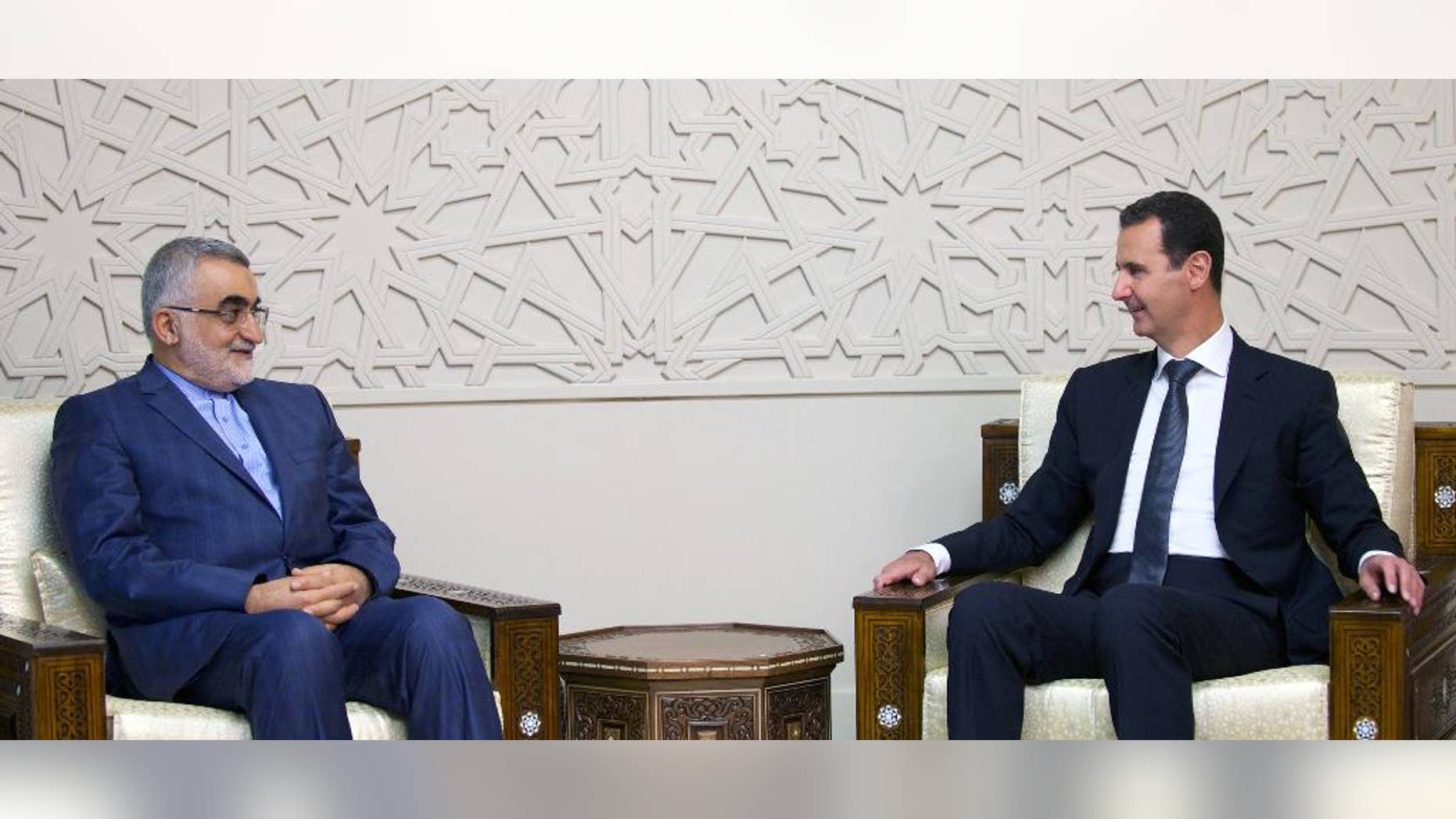 In this photo released by the Syrian official news agency SANA, Syrian President Bashar Assad, right, meets with Alaeddin Boroujerdi, Chairman of the Committee for Foreign Policy and National Security at the Iranian Shura Council, in Damascus, Syria, Thursday, Aug 4, 2016. Boroujerdi said operation by the Syrian government and allied forces in Aleppo aims to "liberate" tens of thousands of residents from the grip of what he called terrorist groups. (SANA via AP)