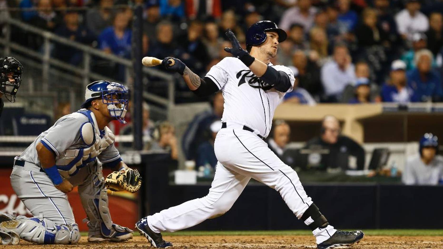 San Diego Padres' Yasmani Grandal and Kansas City Royals catcher Salvador Perez watch as Grandal's 415 foot three run homer heads for the right field seats in the sixth inning of a baseball game Monday, May 5, 2014, in San Diego. (AP Photo/Lenny Ignelzi)