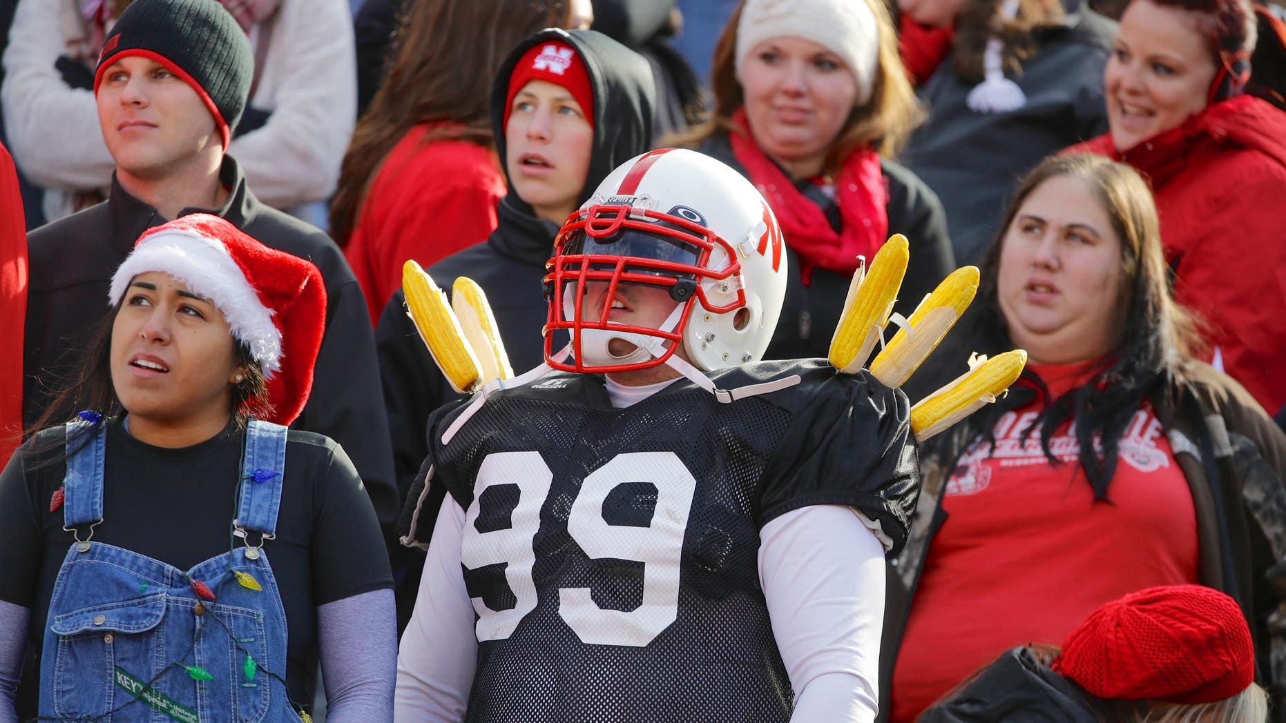 FILE - In this Nov. 29, 2013, file photo, Nebraska fans follow the first half of an NCAA college football game against Iowa in Lincoln, Neb. The Gator Bowl appears to be a tough sell to Nebraska fans. A season that fell well short of expectations will end New Year's Day in Jacksonville, Fla., with a game against Georgia, the same team that beat the Cornhuskers a year ago in the Capital One Bowl. The matchup has elicited little more than a shrug. (AP Photo/Nati Harnik)