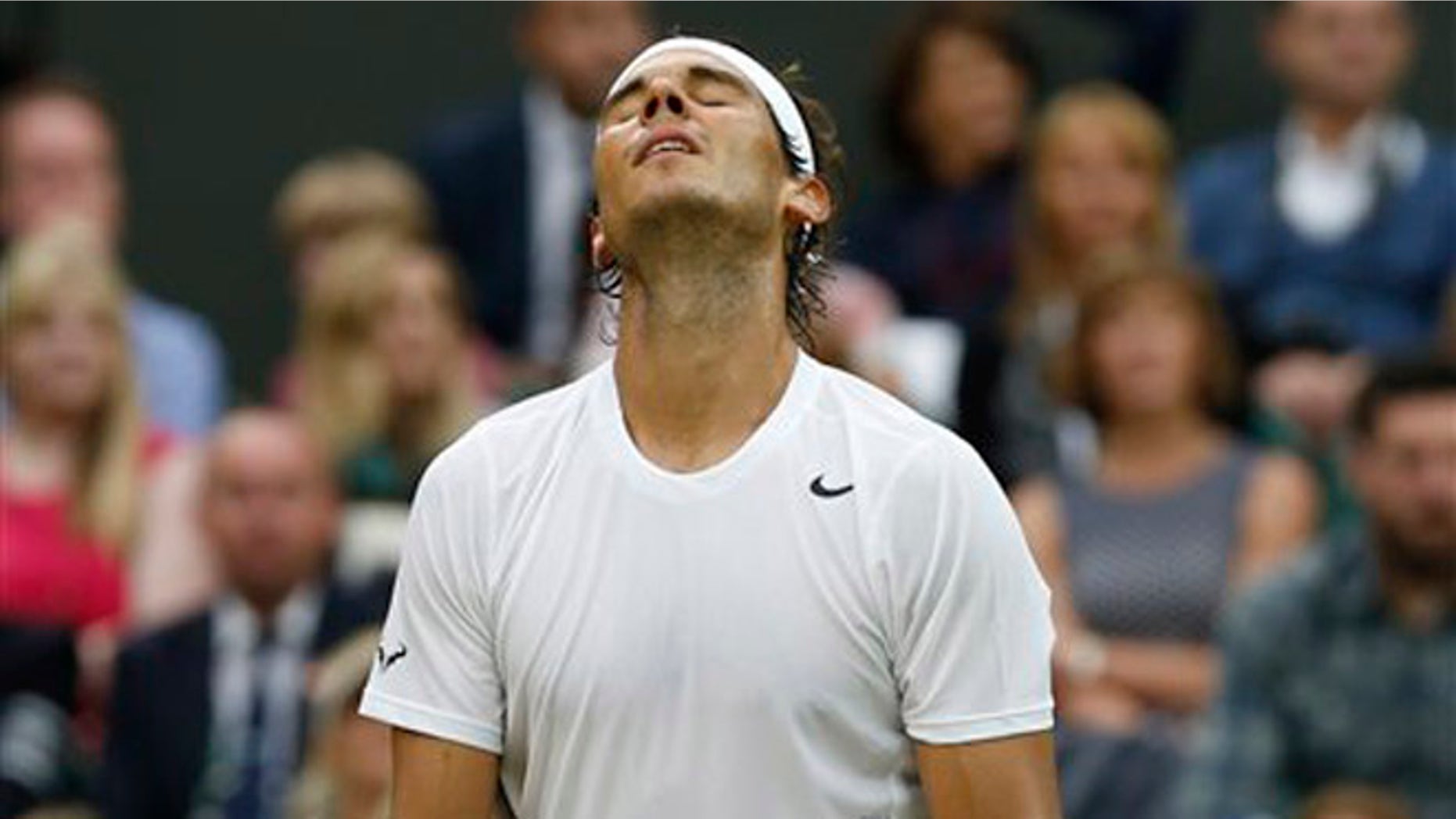 Rafael Nadal of Spain reacts in frustration after missing a point as he plays against Mikhail Kukushkin of Kazakhstan during their men's singles match on Centre Court at the All England Lawn Tennis Championships in Wimbledon, London, Saturday, June 28, 2014. (AP Photo/Ben Curtis)