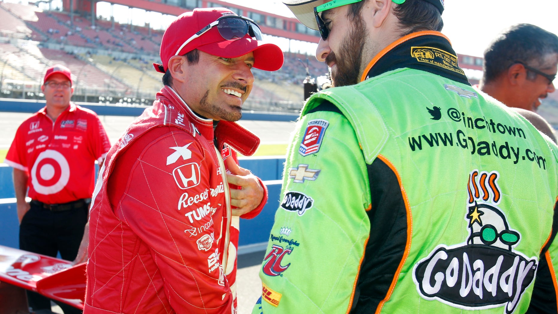 Alex Tagliani, left, of Canada, talks with James Hinchcliffe, of Canada, on pit road, waiting to qualify for Saturday's IndyCar auto race at Auto Club Speedway, Friday, Oct. 18, 2013, in Fontana, Calif. (AP Photo/Alex Gallardo)