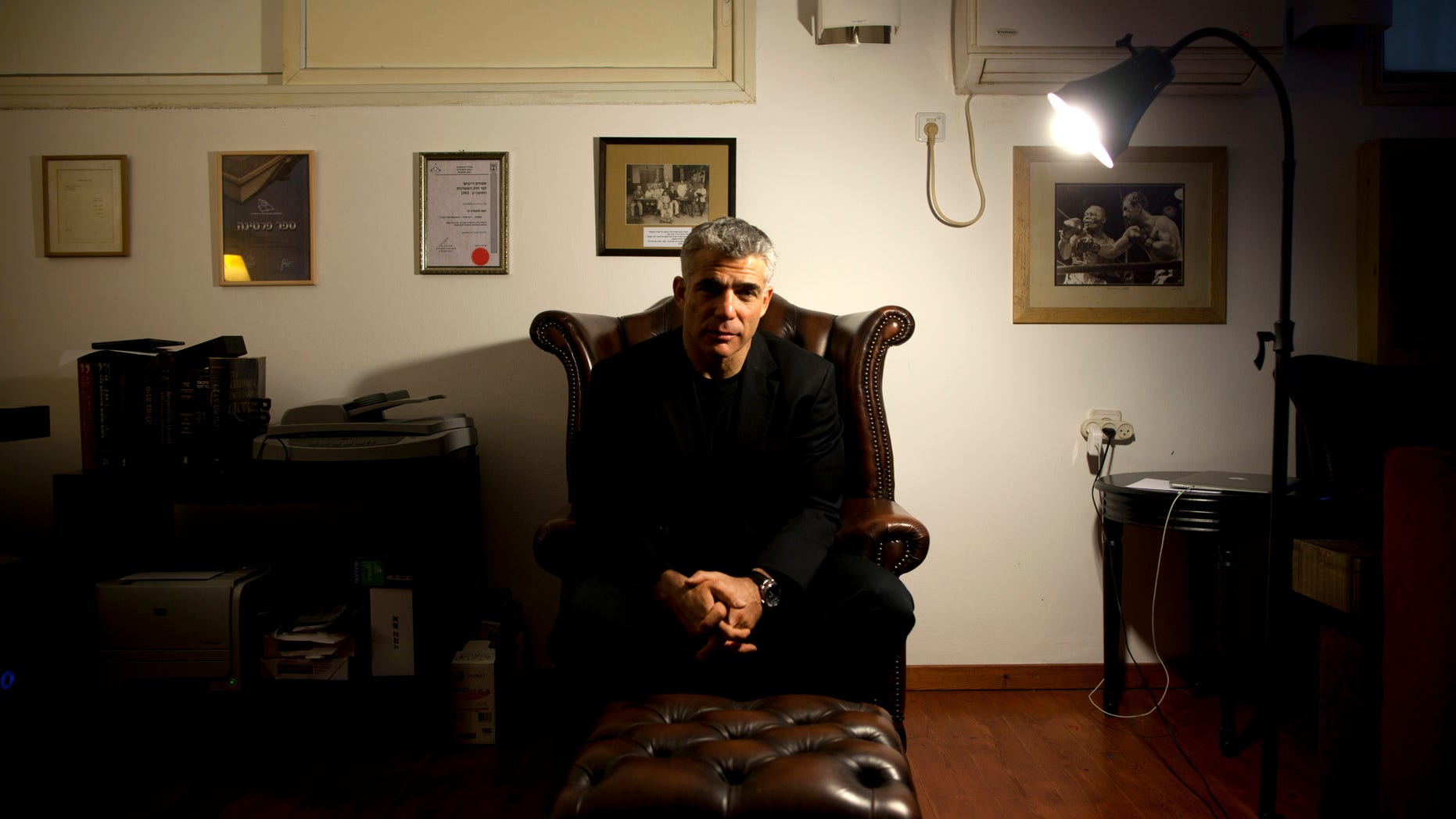 File - In this Jan.16, 2013 file photo, Yair Lapid, popular former TV anchorman and head of the new centrist party Yesh Atid, poses for a portrait at his house during an interview for the Associated Press, in Tel Aviv, Israel. Lapid, Prime Minister Benjamin Netanyahu’s senior coalition partner, said in a published interview Sunday, May 19, 2013, that reaching a final peace agreement with the Palestinians is unrealistic at the current time and that the sides should instead pursue an interim arrangement. (AP Photo/Oded Balilty, File)