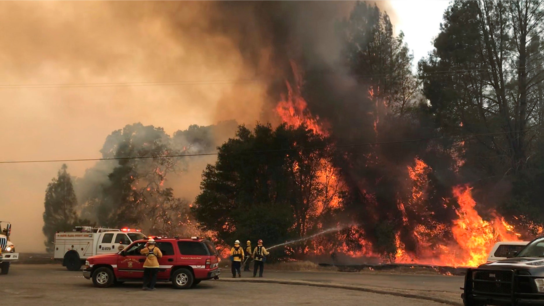 Firefighters battle the wildfire in an area northeast of Clearlake Oaks, Calif.