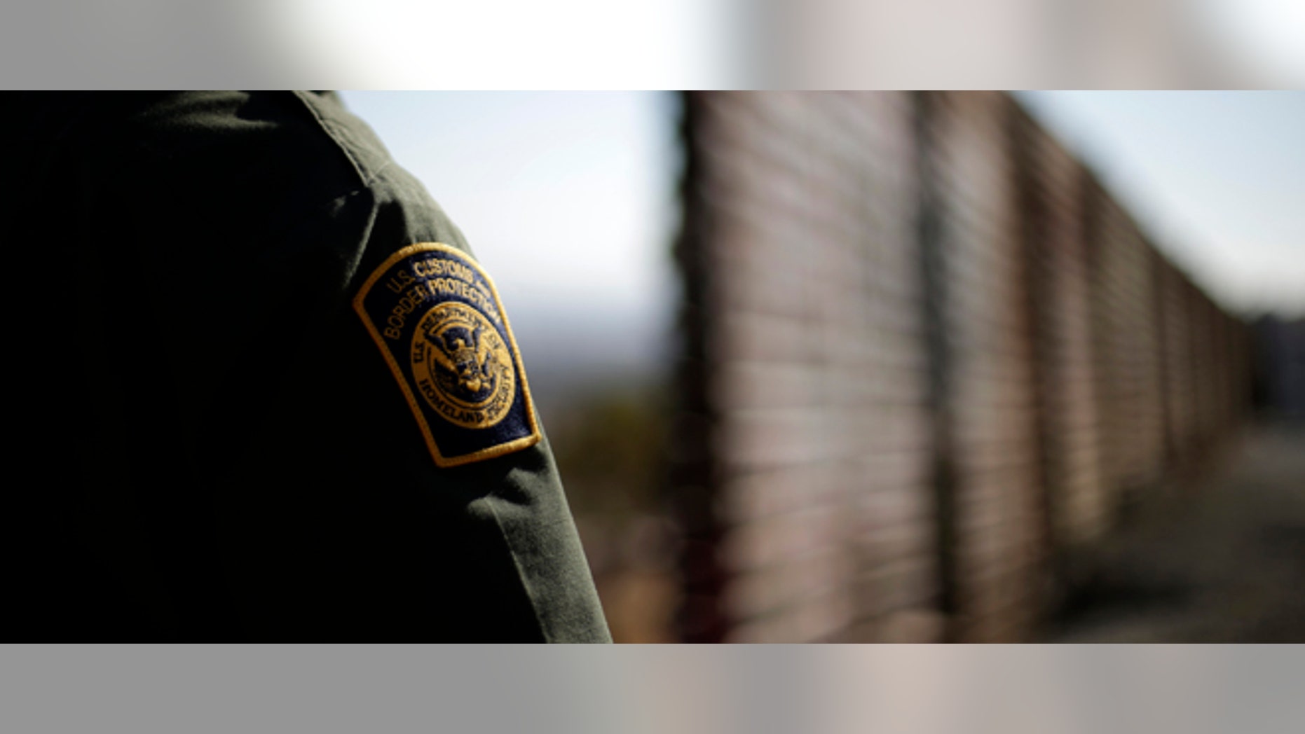 In this June 13, 2013 picture, U.S. Border Patrol agent Jerry Conlin looks to the north near where the border wall ends as is separates Tijuana, Mexico, left, and San Diego, right. Illegal immigration into the United States would decrease by only 25 percent under a far-reaching Senate immigration bill, according to an analysis by the Congressional Budget Office that also finds the measure reduces federal deficits by billions. (AP Photo/Gregory Bull)