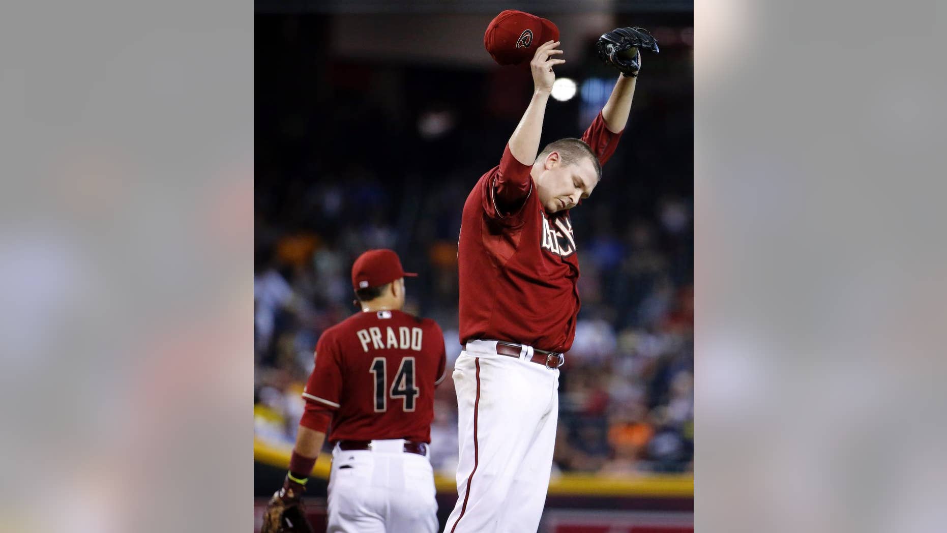 Arizona Diamondbacks pitcher Trevor Cahill wipes his head during the fourth inning of a baseball game against the Detroit Tigers, Wednesday, July 23, 2014, in Phoenix. (AP Photo/Matt York)
