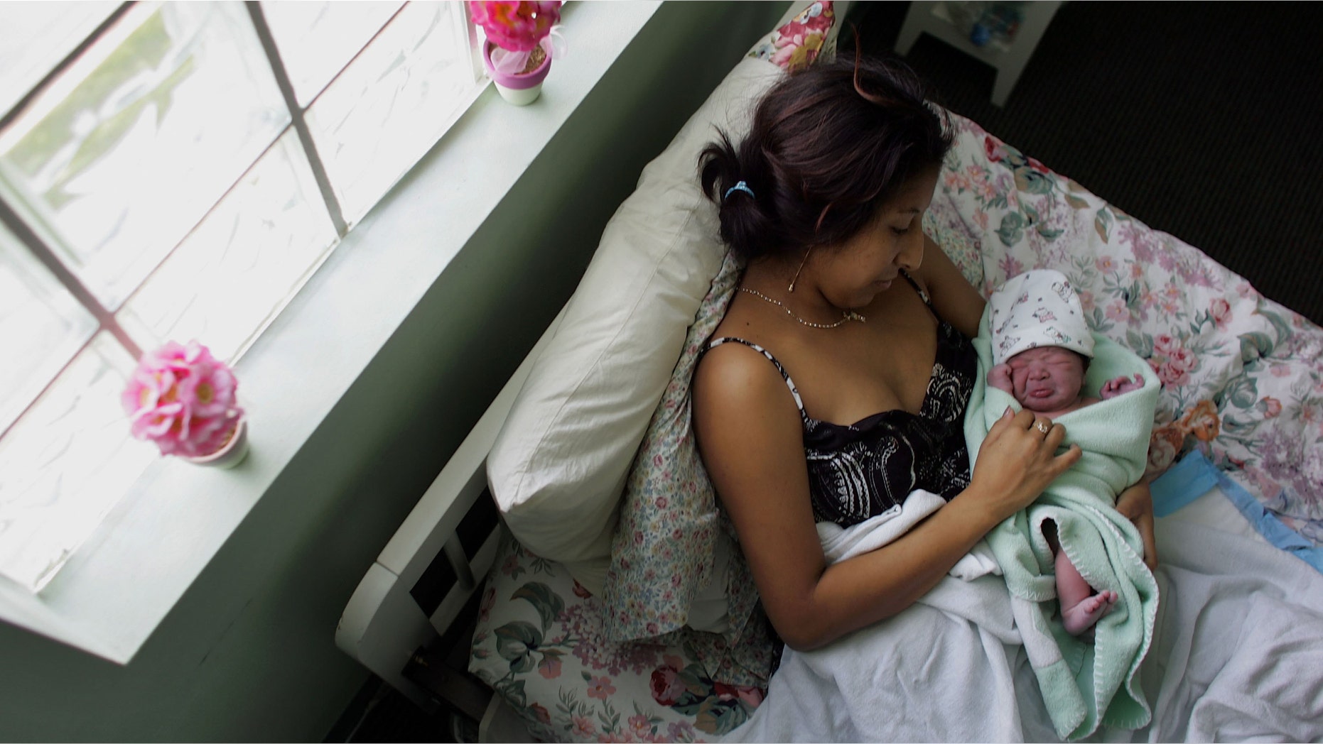 FLORIDA CITY, FL- OCTOBER 16: Yailin Melissa Turcios, who was about 20 minutes prior, lies in the arms of her mother, Rosa Turcios, on a bed at the Birthing Center of South Florida October 16, 2006 in Florida City, Florida. This week the population of the United States will reach 300 million people. The excess of U.S. births over deaths accounted for about 1.7 million new Americans between 2004 and 2005, according to official figures. Another 1 million were added by immigration. The United States will remain the world's third most populous country after China and India. (Photo by Joe Raedle/Getty Images)