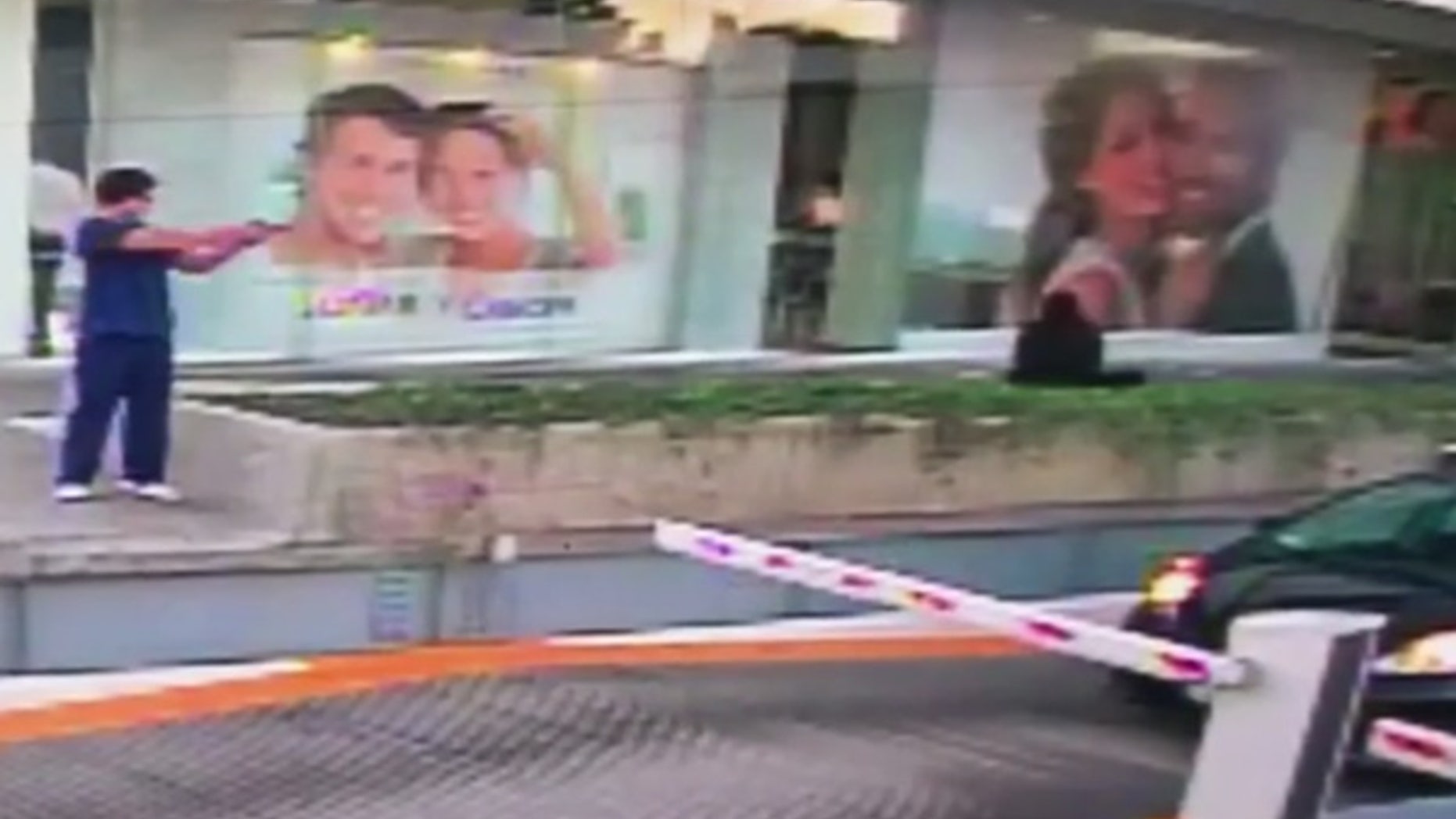 A gunman fires a shot at the car of a U.S. Consulate official in this still from a surveillance video.