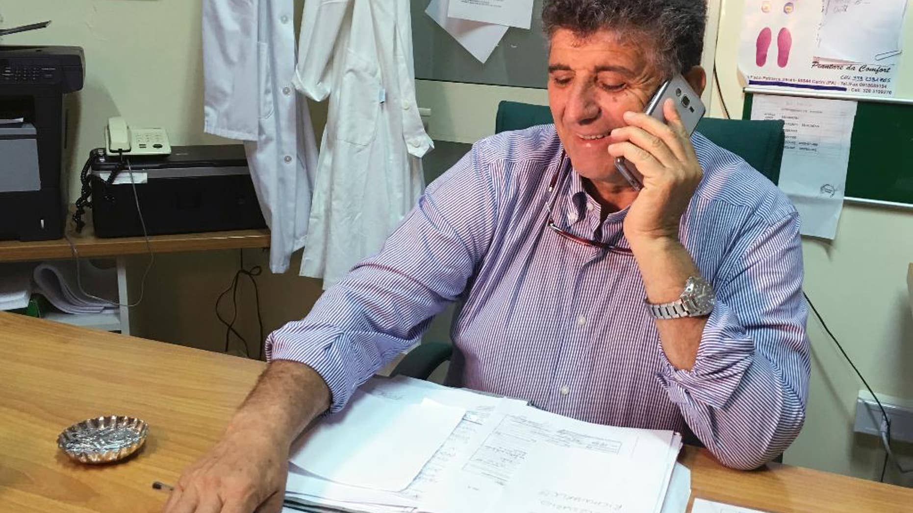 Doctor Pietro Bartolo is pictured in his studio in Lampedusa first aid center, Saturday, May, 28, 2016. Bartolo wants to adopt an orphan baby who was rescued and treated by him last Thursday in Lampedusa. Favour, the 9-months baby, arrived on the tiny Sicilian island onboard an Italian Coast Guard ship, after being rescued at sea off Libyan coasts. Her mother, a Nigerian woman, died during the journey because she suffered burns believed to be caused by extended contact with fuel and sea water. (AP Photo/Annalisa Camilli)
