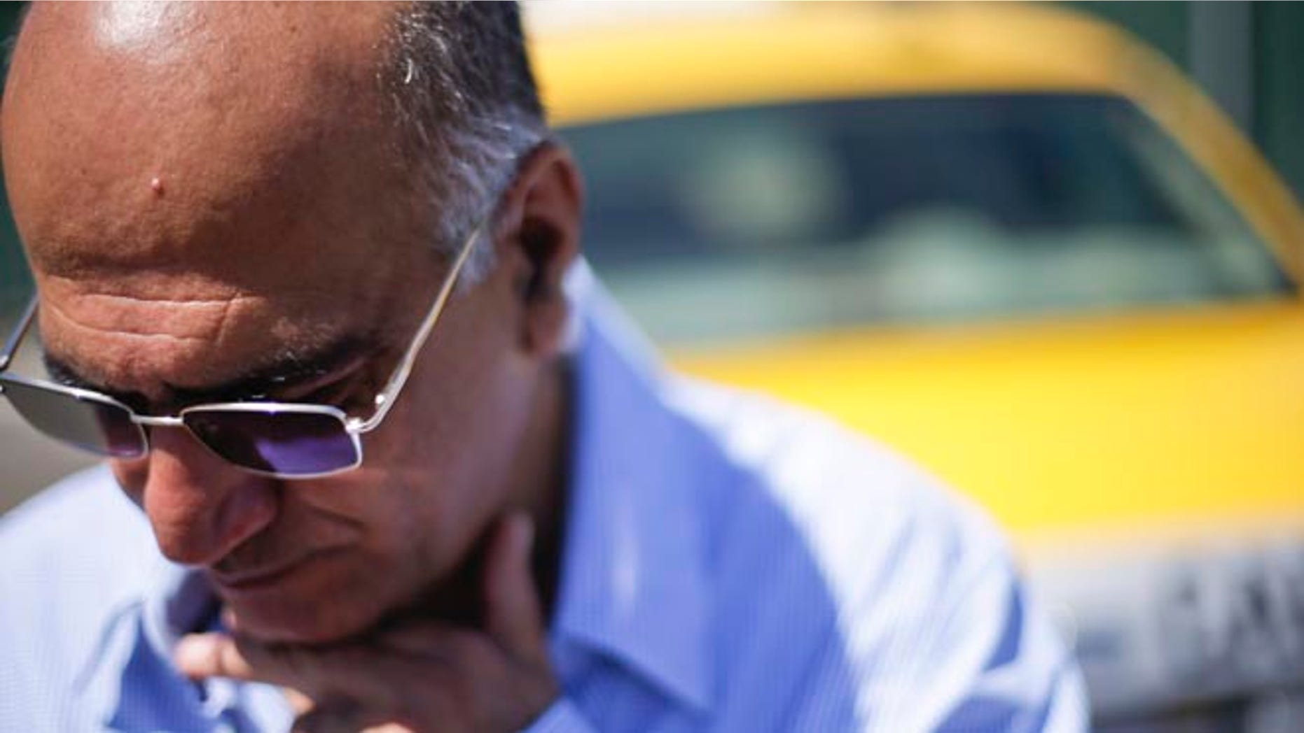 Sept. 10, 2014: Cab driver Martin Salami looks down as he talks about new ordinances facing drivers at a depot near the airport in San Diego.