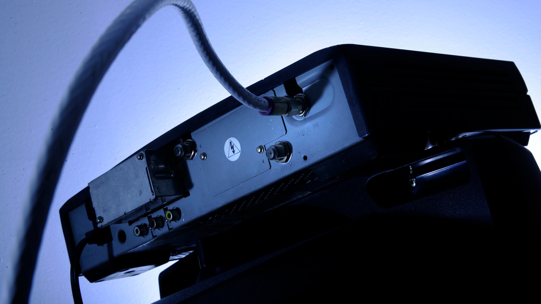 FILE - This Wednesday, May 30, 2007, file photo shows a cable box on top of a television in Philadelphia. Cable and satellite TV providers are ringing in 2018 with an unwelcomed gift: higher cable bills. Although annual rate hikes are inevitable, many consumers manage to lower their bills by pushing back and getting promotional rates. (AP Photo/Matt Rourke, File)