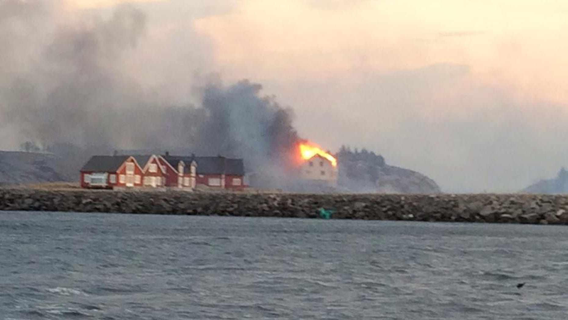 In this image taken from a rescue boat, buildings are seen on fire in Hasvaag, some 240 km north of Trondheim, Norway, Tuesday, Jan. 28, 2014. All of Hasvaag's 50-70 buildings have reportedly burned down. There have been no injuries, but all of the twenty people present have been evacuated. Many of the buildings are summer houses and cabins. (AP Photo/NTB Scanpix, Redningsskoyta Harald V) NORWAY OUT