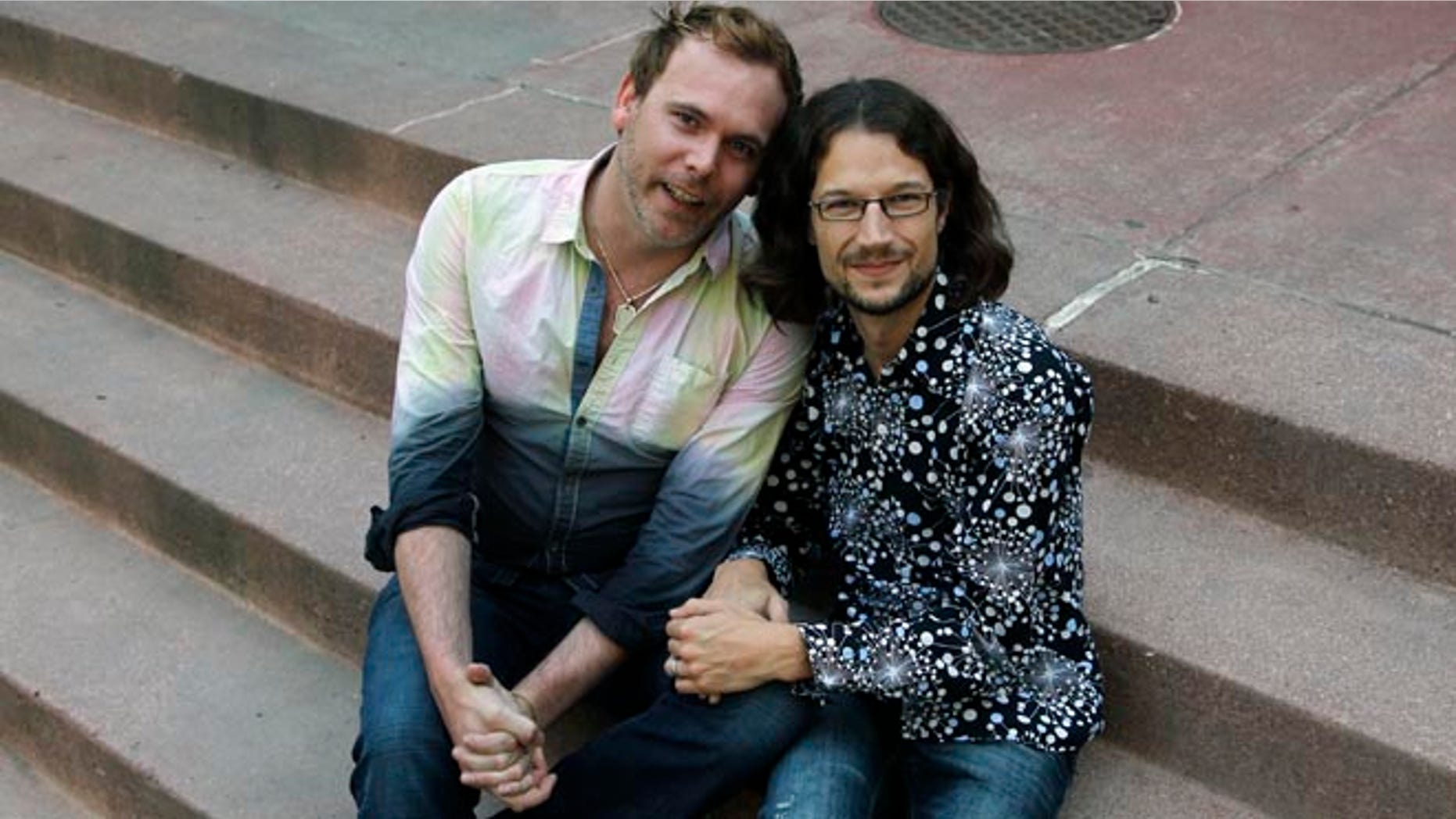 June 6, 2013: This file photo shows Dave Mullins, right, sitting for a portrait with his husband Charlie Craig, in Denver.