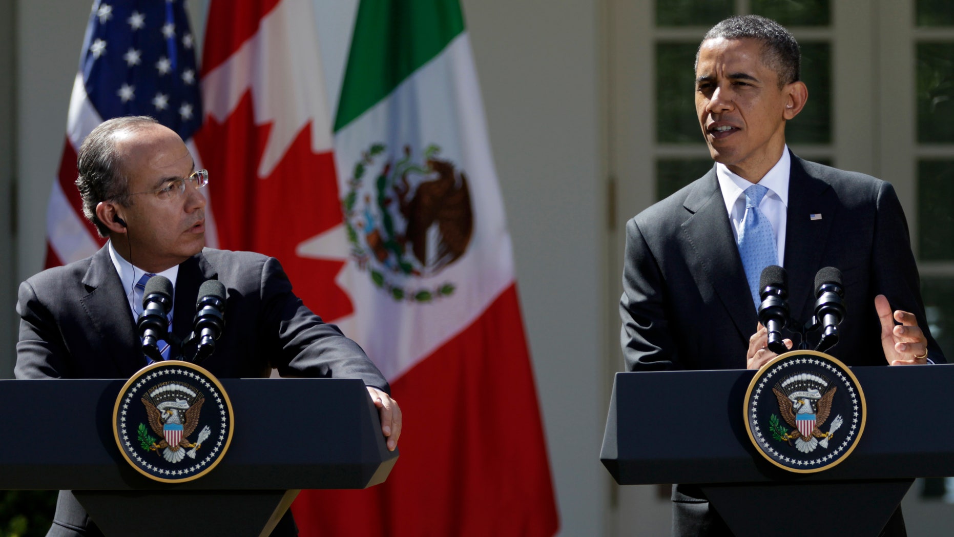 Mexican President Felipe Calderon watches at left as President Barack Obama speaks during a joint news conference with Canadian Prime Minister Stephen Harper, not seen, Monday, March 2, 2012, in the Rose Garden of the White House in Washington. (AP Photo/Carolyn Kaster)