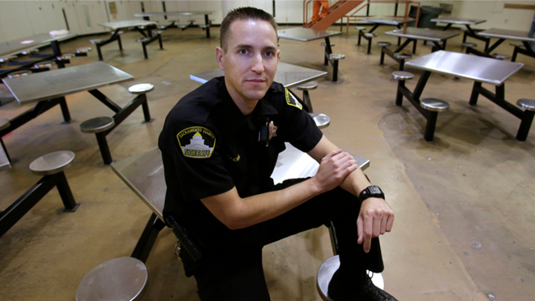 In this Wednesday, Aug. 14, 2013, photo, Sacramento County Deputy Sheriff Kenny Gouveia poses in the housing unit where he was attacked and injured while trying to settle a dispute between two inmates at the Sacramento County Jail. Gouveia was off work for five days while he recovered from the injuries sustained when a 26-year-old inmate attacked him, slamming his head into a food cart and choking him. County jails across California have seen a marked increase in violence since they began housing thousands of offenders who previously would have gone to state prisons.