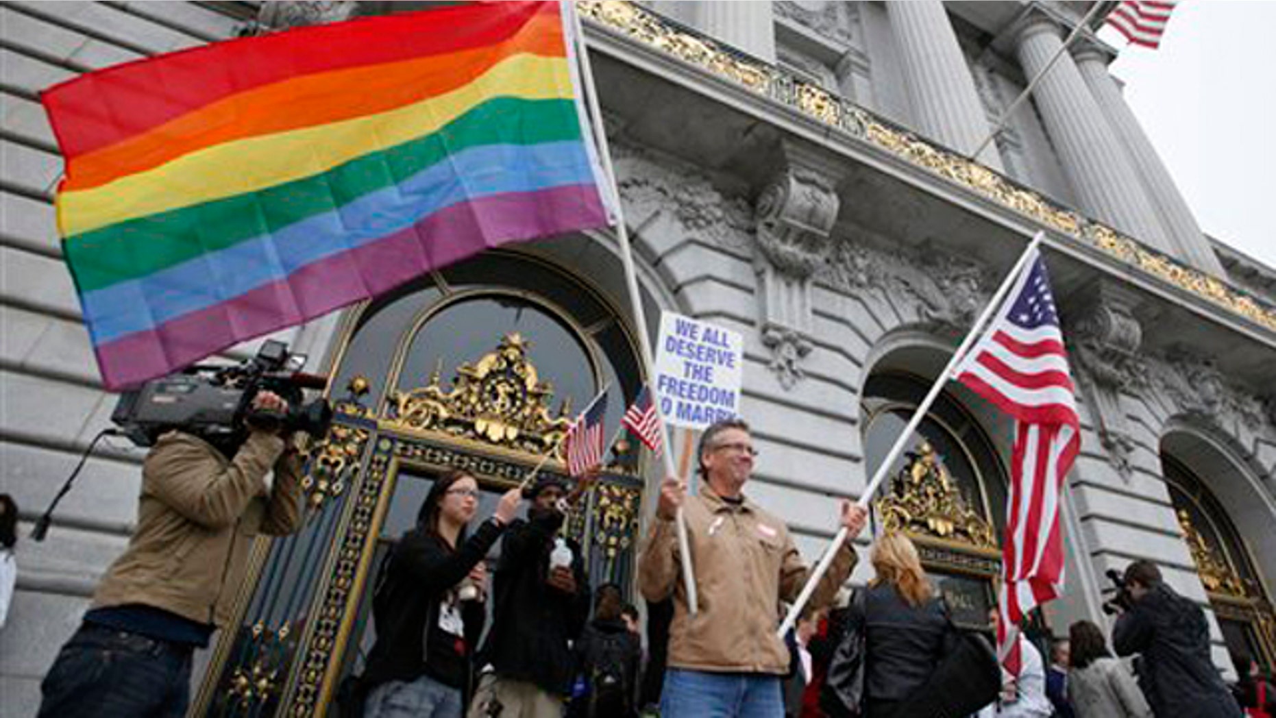Aug. 12, 2010: Billy Bradford of Castro Valley, Calif., waves a pair of flags outside City Hall while same-sex couple line up to see if they can be married in San Francisco. A federal appeals court is ready to announce its ruling on whether California's same-sex marriage ban violates the constitutional rights of gays and lesbians.
