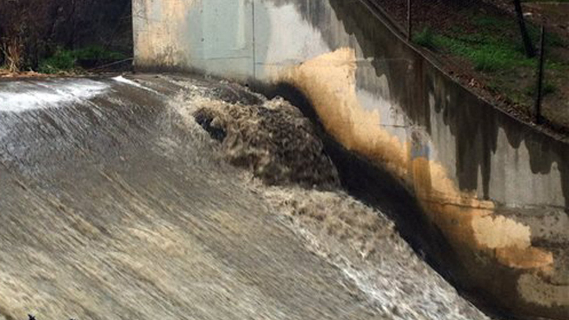 Runoff gushes down a spillway in the Arroyo Seco, which translates to 'dry creek' or 'dry stream' in Spanish, in Pasadena, Calif., as rain drenches the region Sunday, Jan. 31, 2016.