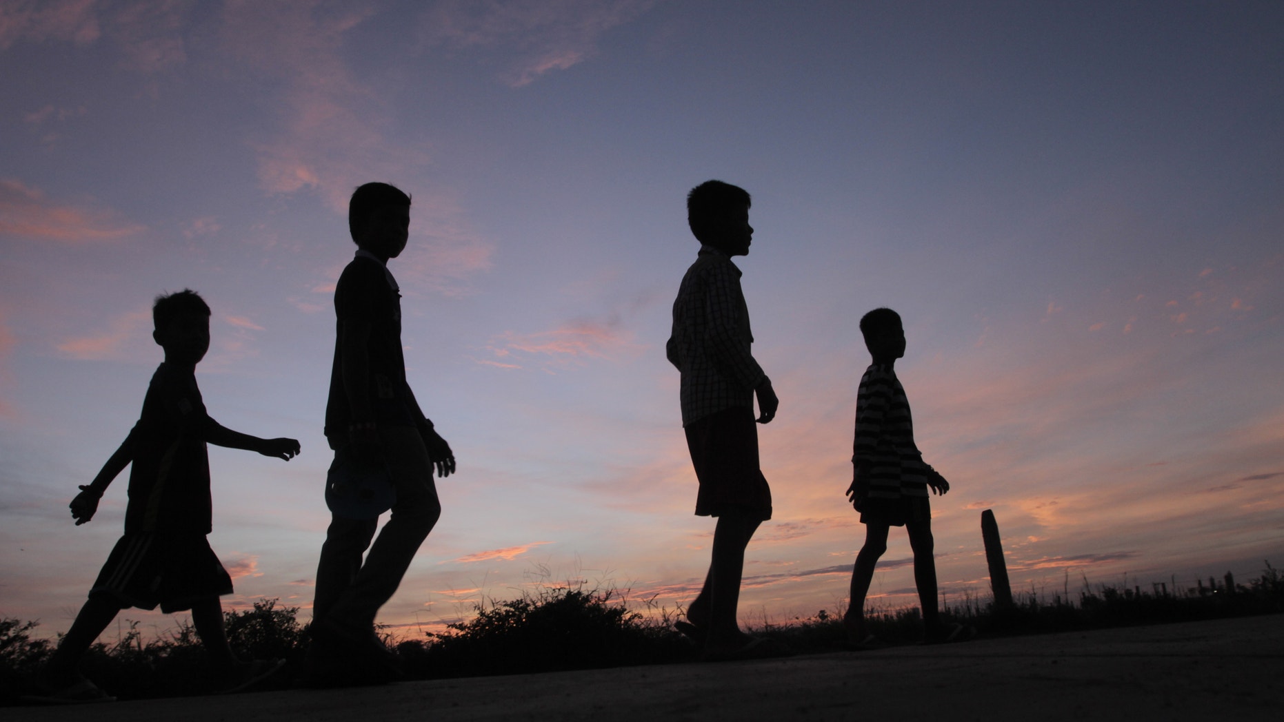 Local boys head back their home after an offering food on the ground at a Buddhist pagoda of Kob Srov on the outskirt of Phnom Penh, Cambodia, early Sunday morning, Sept. 25, 2016. Cambodians pay their respects to deceased relatives during the traditional 15-day Pchum Ben festival. (AP Photo/Heng Sinith)