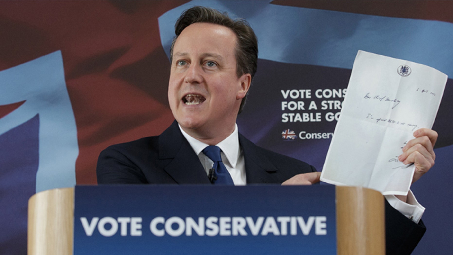 British Prime Minister David Cameron holds up a photocopied note left by former chief secretary to the Treasury Liam Byrne on his desk after Labour's 2010 election defeat, which reads "Dear Chief Secretary, I'm afraid there is no money. Kind regards - and good luck! Liam." as he delivers a speech at the Ambleside Sports Club in Nuneaton, England, Sunday, May 3, 2014. Britain goes to the polls in a General Election on May 7. (AP Photo/Tim Ireland, Pool)