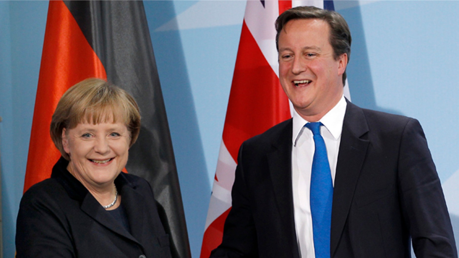 Nov. 18, 2011: German Chancellor Angela Merkel, left, and British Prime Minister David Cameron, right, shake hands after a news conference during a meeting at the chancellery in Berlin, Germany.