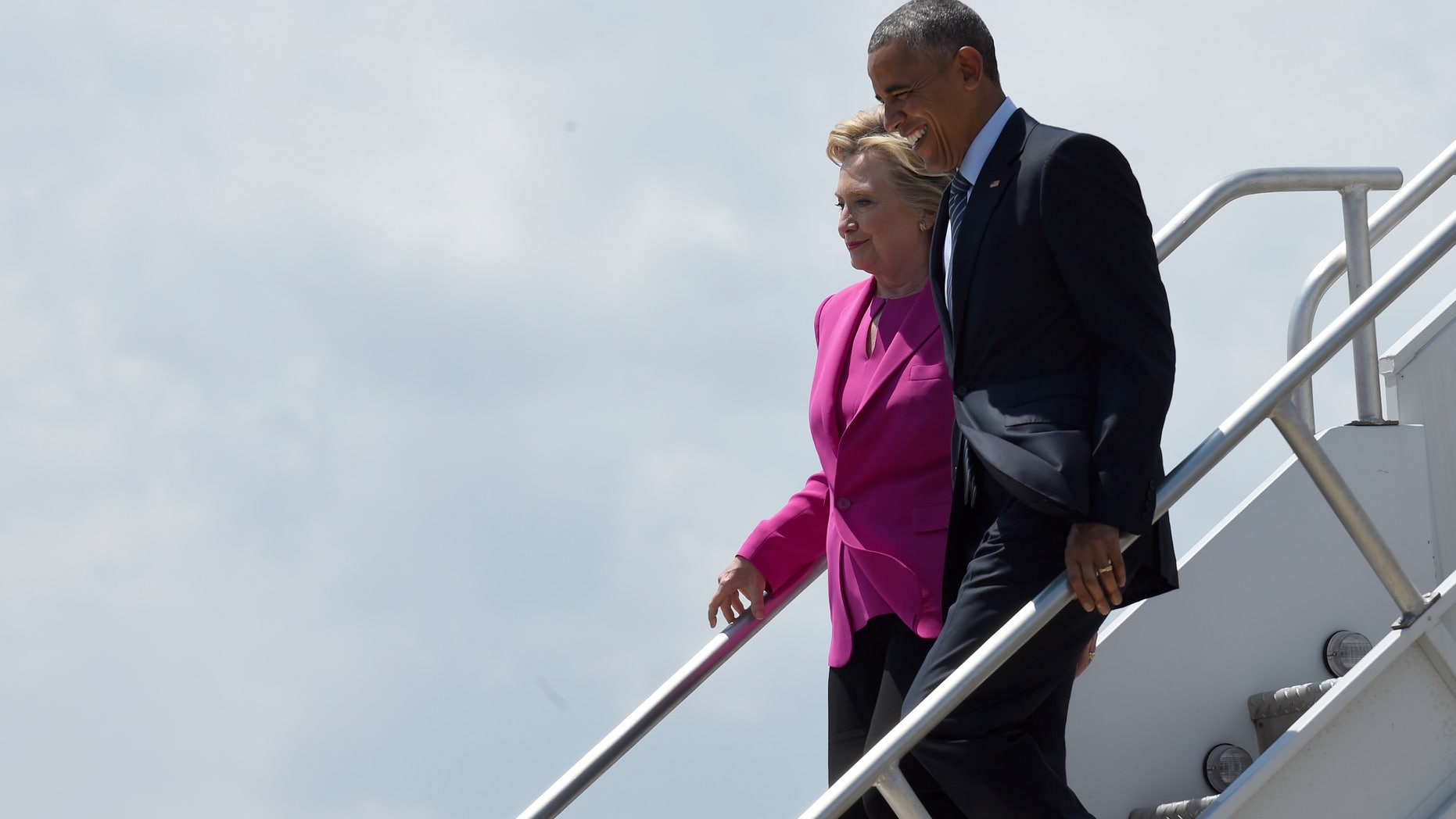 FILE -- July 5, 2016: President Obama and Democratic presidential candidate Hillary Clinton walk down the steps of Air Force One after arriving at North Carolina Air National Guard Base in Charlotte, N.C.