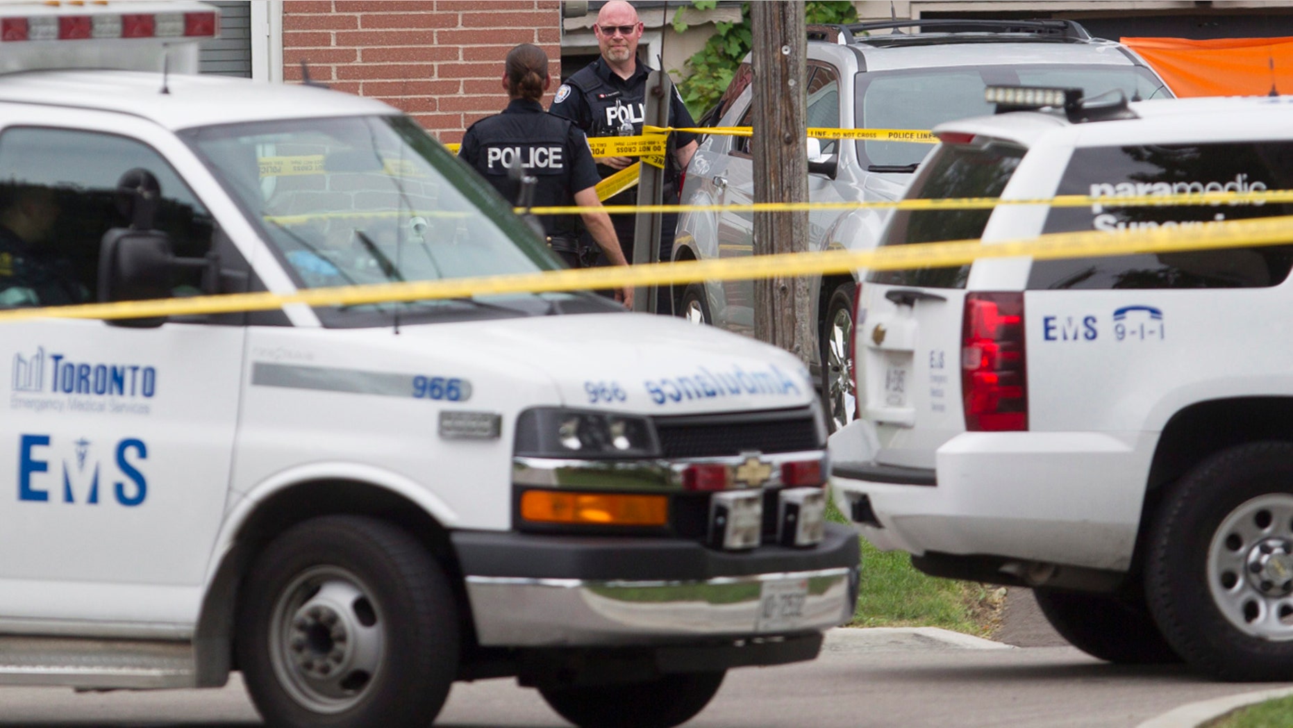 Aug. 25, 2016: Police stand in front of a house in Scarborough, Ont. after three people were killed in a crossbow incident