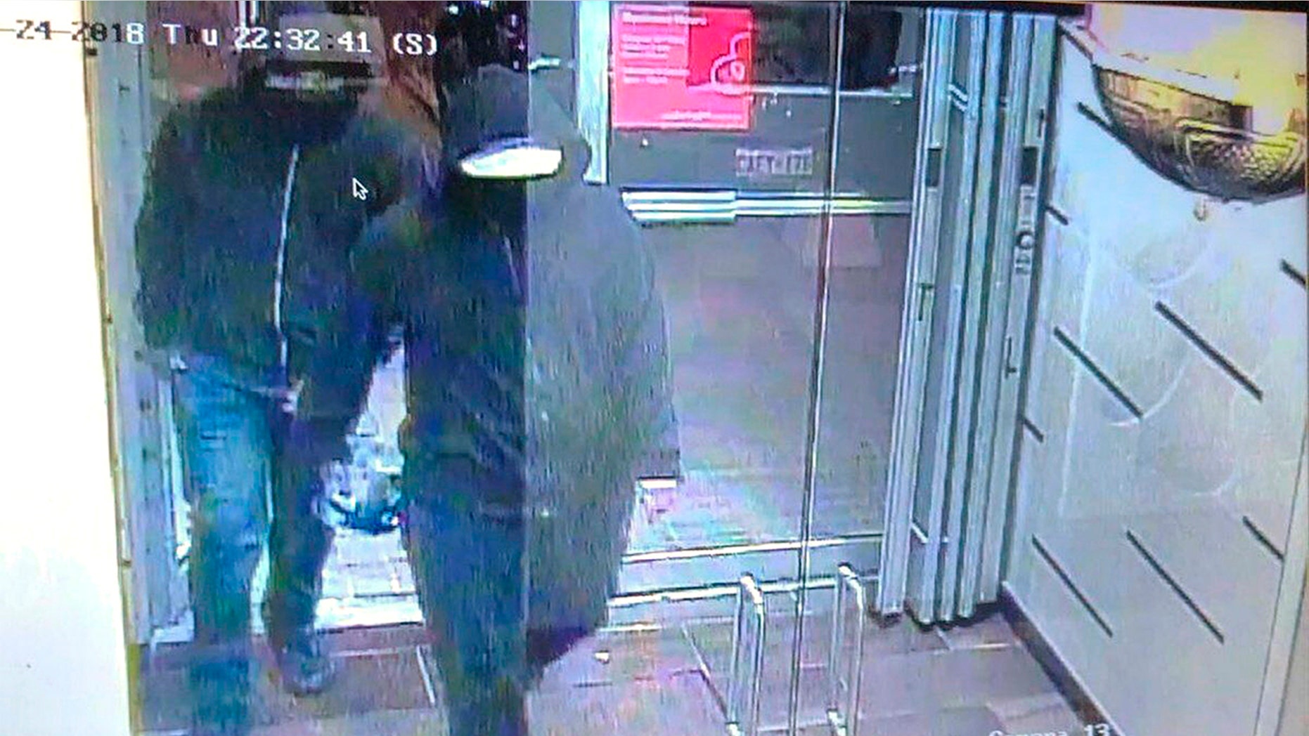 In this image made from CCTV footage released by Peel Regional Police, two suspects enter a glass doorway of the Bombay Bhel Indian restaurant, late Thursday, May 24, 2018, in Mississauga, suburb of Toronto, Canada. Police are searching for the two suspects in connection with the explosion caused by "improvised explosive device" that ripped through the restaurant, wounding 15 people, Canadian police said.