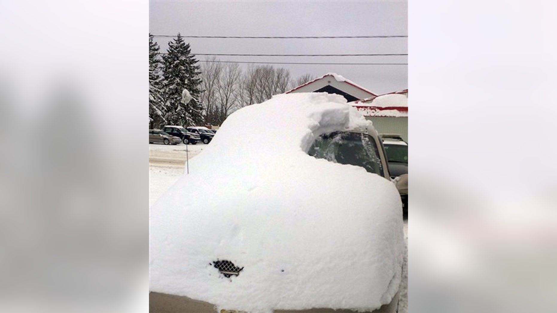 This Tuesday, Jan. 19, 2016 photo provided by the Ontario Provincial Police shows a snow covered vehicle in Brussels, Ontario. (Sgt. Russell Nesbitt/Ontario Provincial Police via AP)