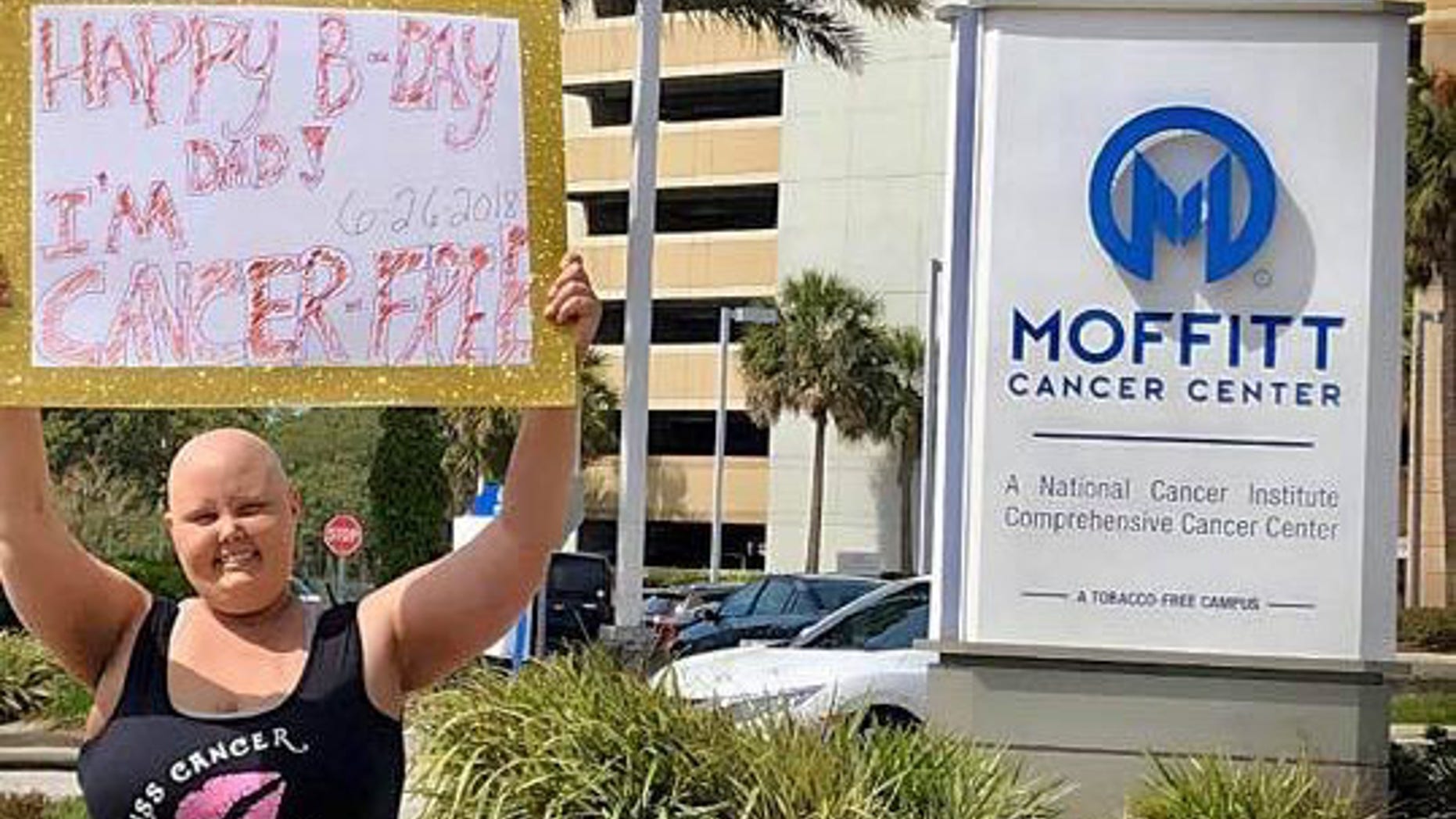 Cori holds sign outside Moffitt Cancer Center