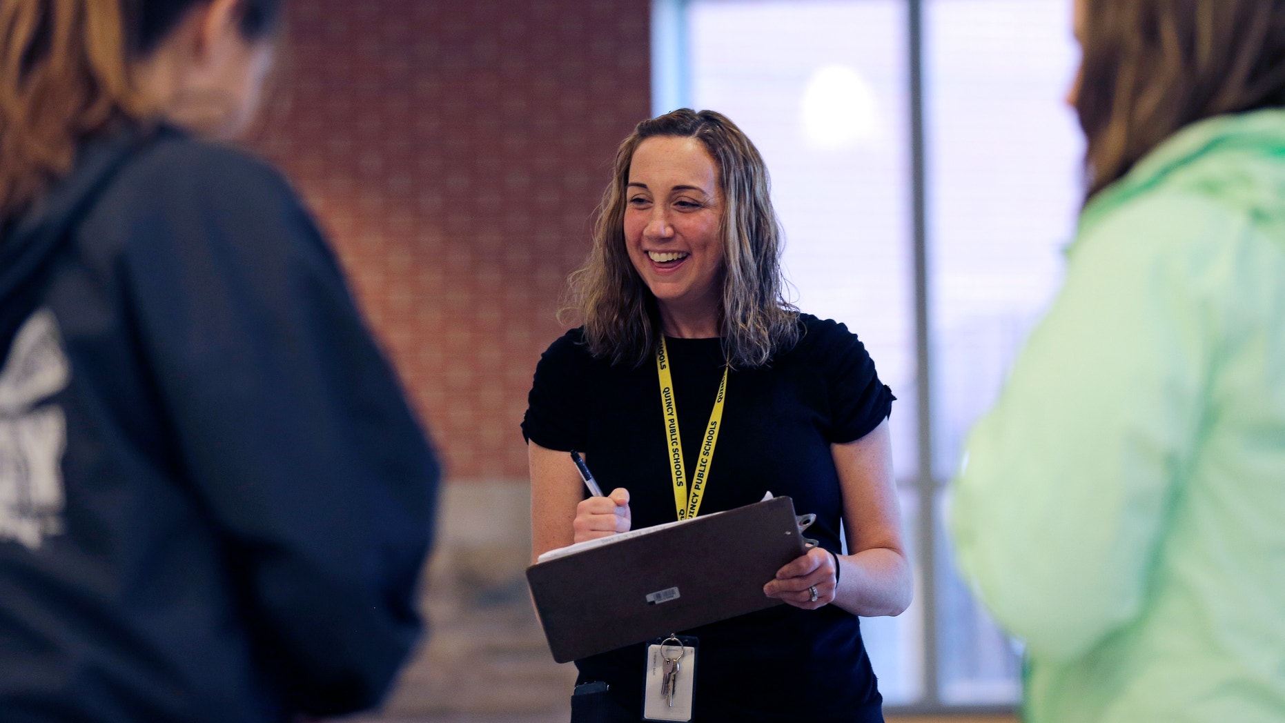 Cancer survivor Christine Ells talks with her students as she takes attendance at Quincy High School in Quincy, Mass., Monday, Nov. 9, 2015. Ells, 36, a teacher in the Boston suburb of Quincy, developed a heart rhythm problem from several drugs she was given to treat the breast cancer she was diagnosed with at age 27. (AP Photo/Charles Krupa)