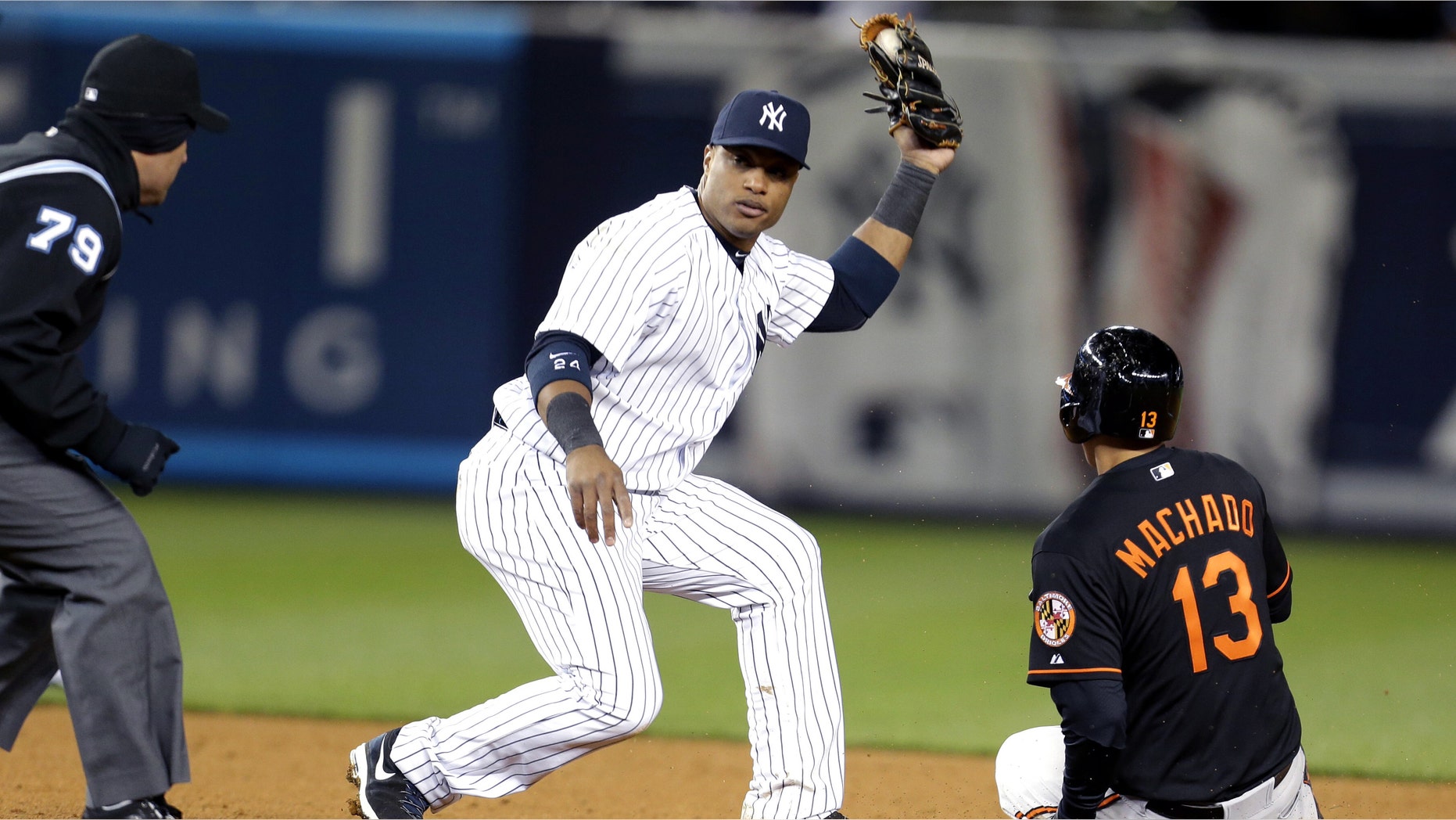 New York Yankees second baseman Robinson Cano, center, waits for the call from second base umpire Manny Gonzalez, left, after tagging Baltimore Orioles' Manny Machado for the third out of a triple play during the eight inning of a baseball game at Yankee Stadium in New York, Friday, April 12, 2013. (AP Photo/Julio Cortez)