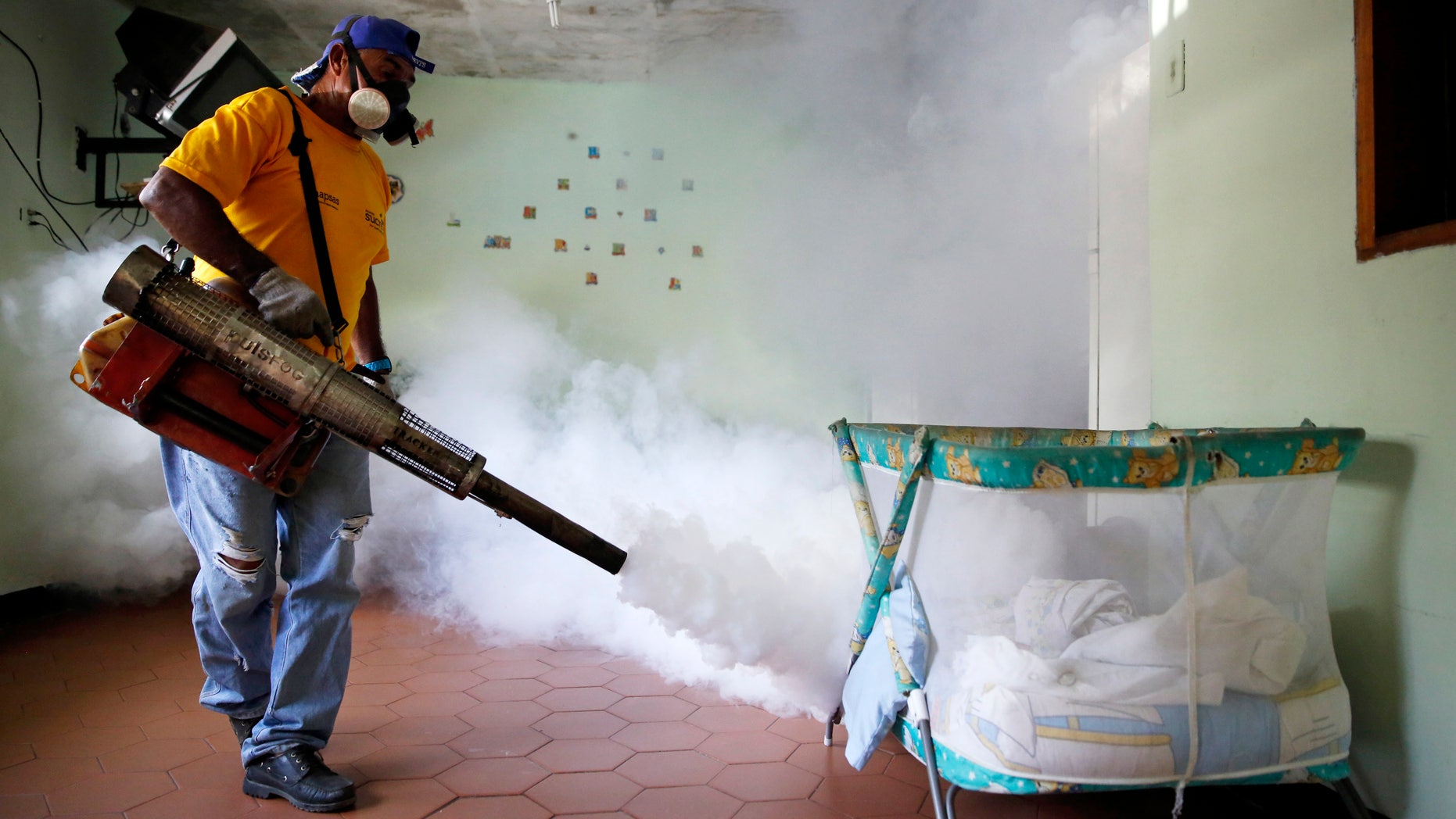 A worker from the municipality of Sucre carries out fumigation to help control the spread of Chikungunya and dengue fever, which are caused by viruses carried by mosquitoes, in the Petare slum district of Caracas September 22, 2014. REUTERS/Carlos Garcia Rawlins