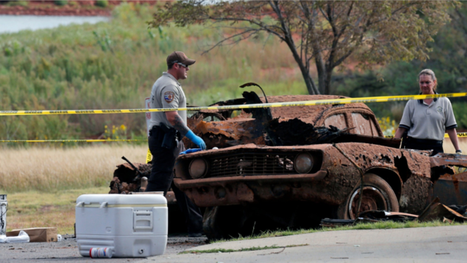 Sept. 18, 2013. Law enforcement officials from multiple agencies examine the two cars pulled from Foss Lake, in Foss, Okla.