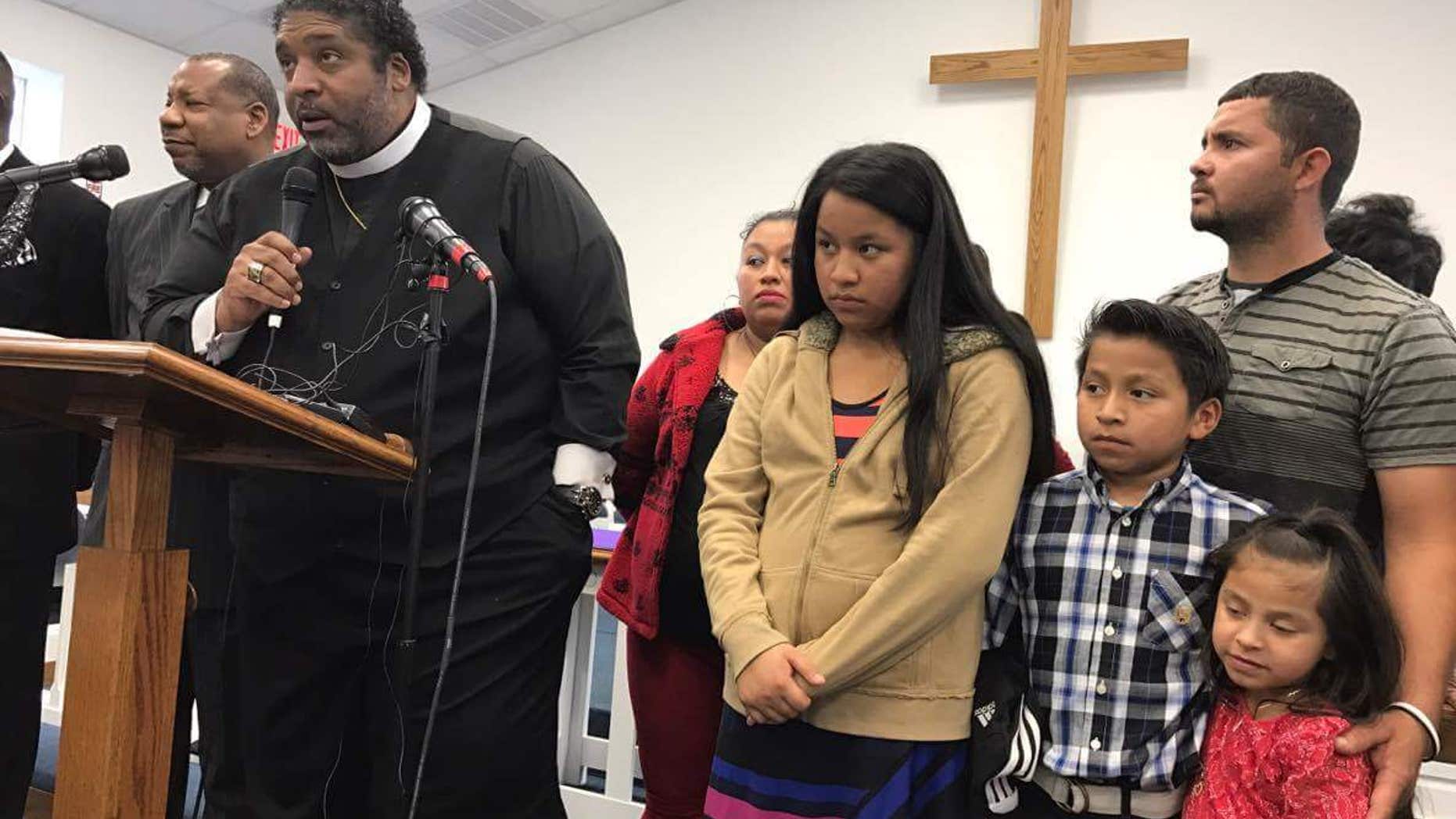 Lilian Cardona-Perez in the background along with a Minister, her children and husband