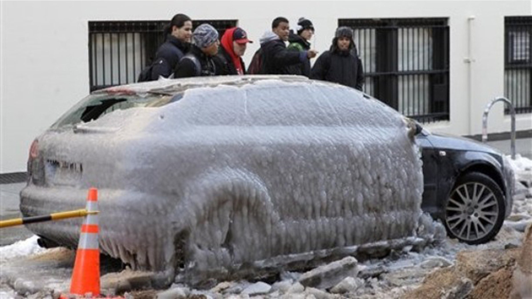 Jan. 24: Pedestrians gawk at Pete Helfer's car, frozen under a sheet of ice on a New York City street after a water pipe broke nearby (AP).