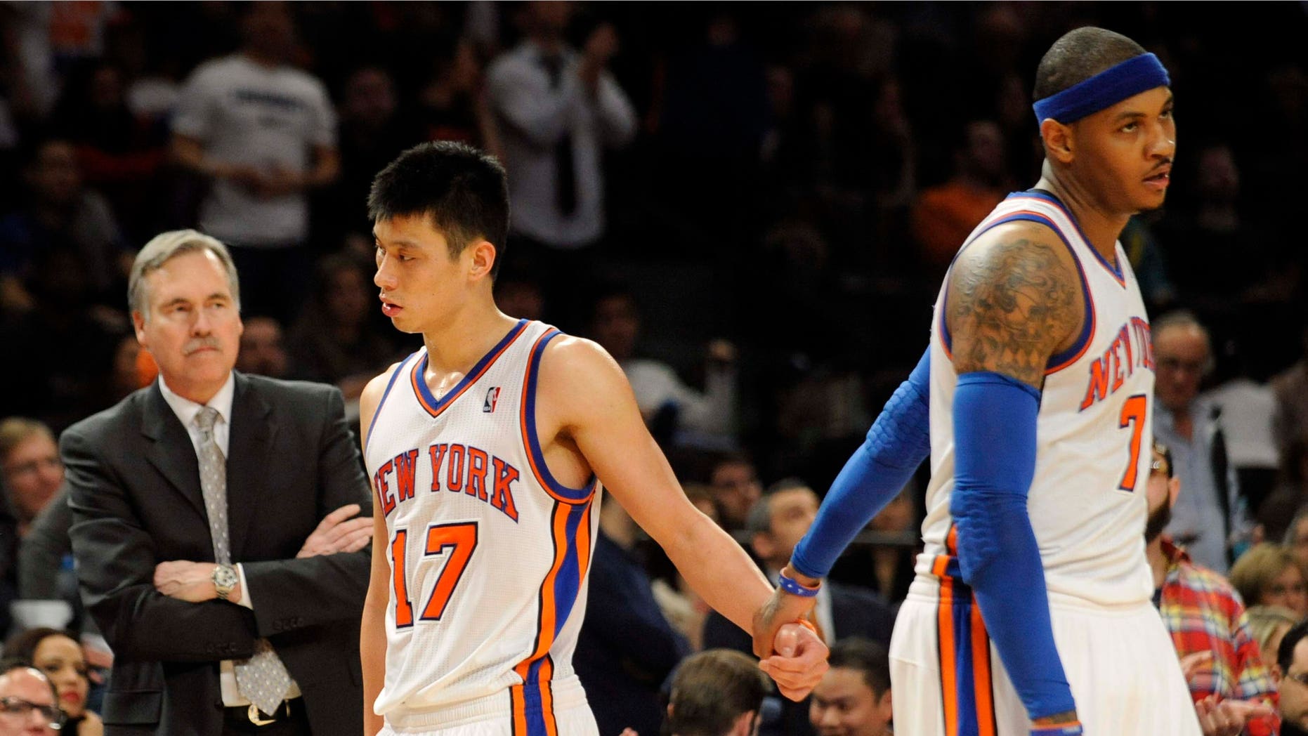 New York Knicks' Carmelo Anthony, right, holds Jeremy Lin's hand as he leaves the game after fouling out during the fourth quarter of an NBA basketball game against the New Jersey Nets, Monday, Feb. 20, 2012, at Madison Square Garden in New York. The Nets defeated the Knicks 100-92. Anthony shot 4 of 11 and scored 11 points. Lin finished with 21 points, nine assists and seven rebounds. At left is Knicks coach Mike D'Antoni. (AP Photo/Bill Kostroun)