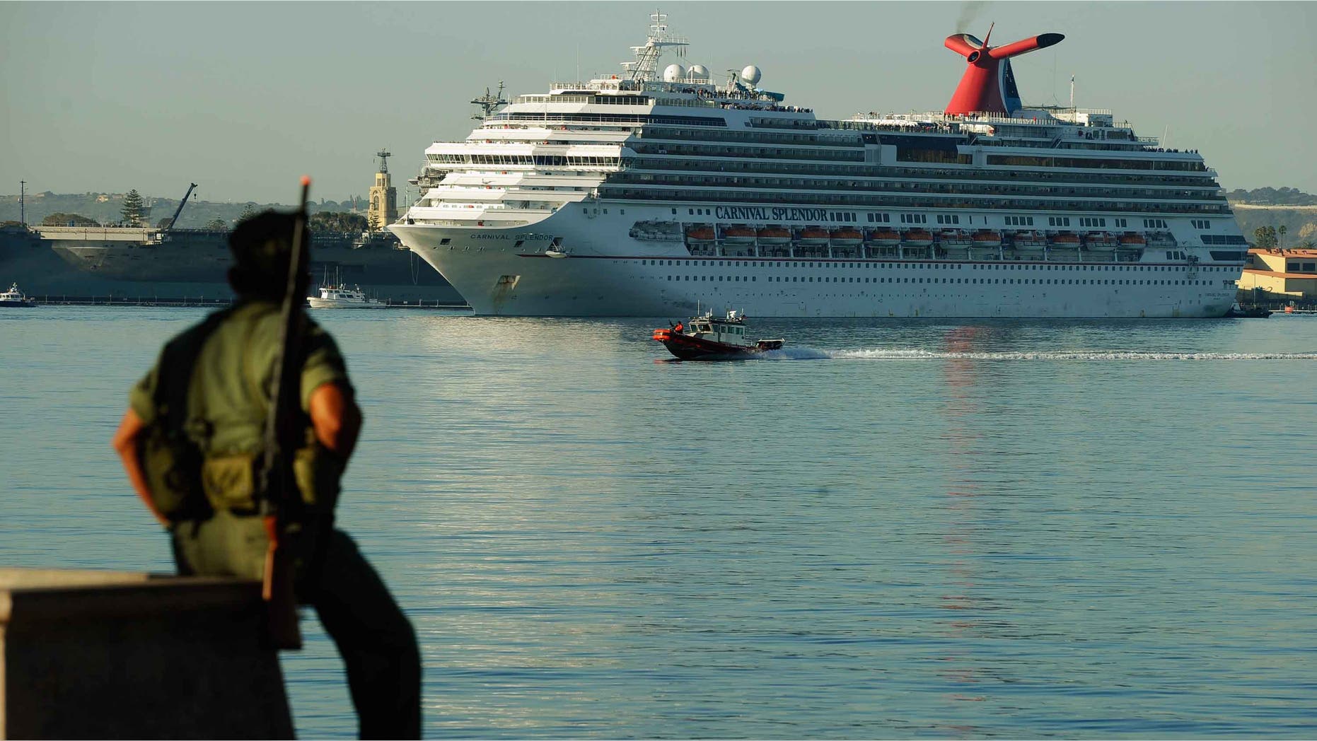 SAN DIEGO - NOVEMBER 11: The stranded Carnival Splendor cruise ship is towed to San Diego Harbor by tug boats on November 11, 2010 in San Diego, California. The cruise ship lost power and became stranded off of California's coast early Monday after a fire in the engine room. A military service member in observance of Veterans Day looks on. (Photo by Kevork Djansezian/Getty Images)