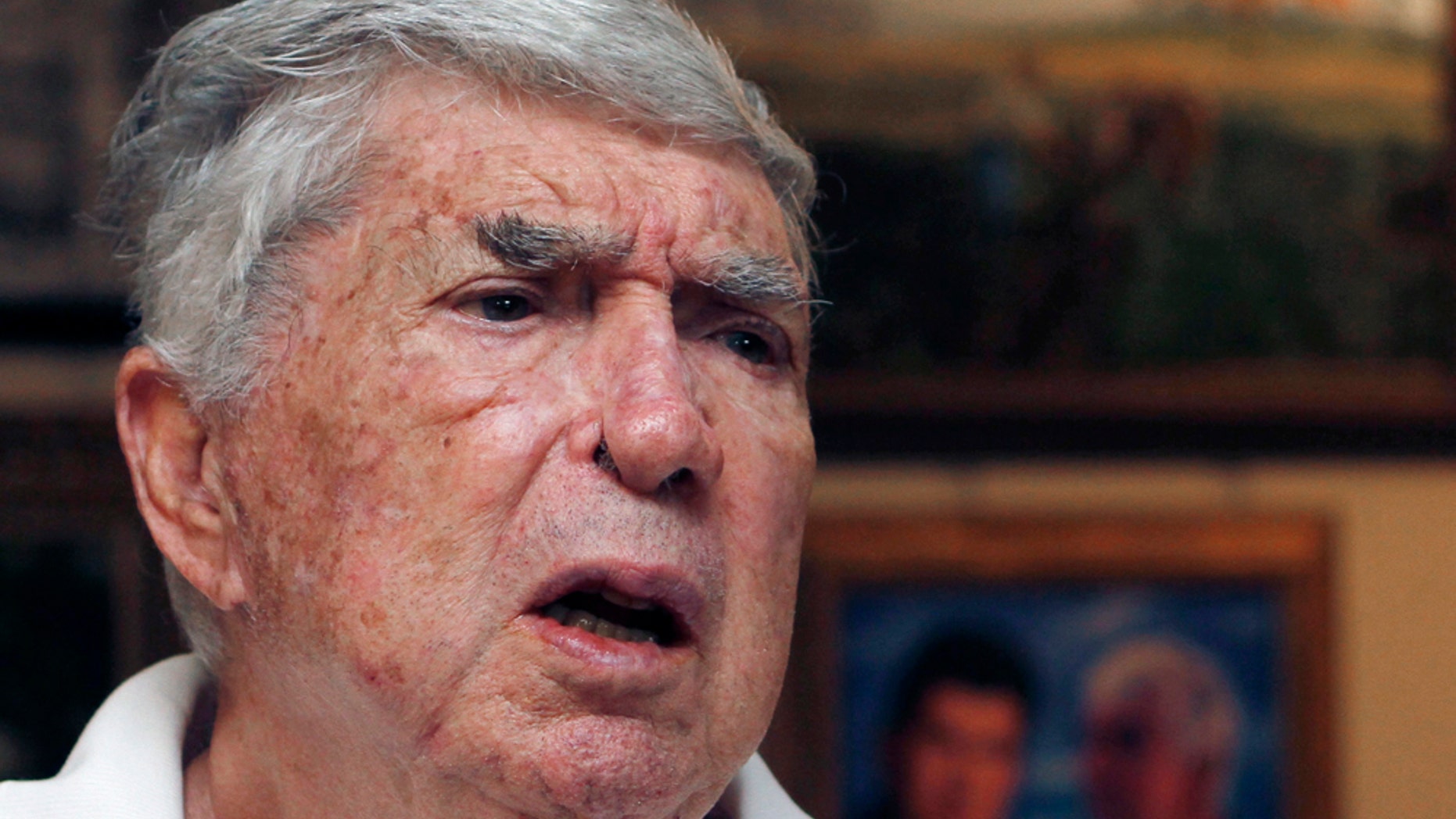 FILE - In this Nov. 8, 2010, file photo Luis Posada Carriles talks to a reporter in Miami. The former CIA operative is on trial in El Paso, Texas, facing 11 counts of perjury, obstruction and naturalization fraud. He's accused of making false statements in 2005 for allegedly lying during immigration interviews in El Paso about how he got into the U.S. and about his role in a string of 1997 bombings that rocked Havana hotels and killed an Italian tourist. (AP Photo/Alan Diaz, File)