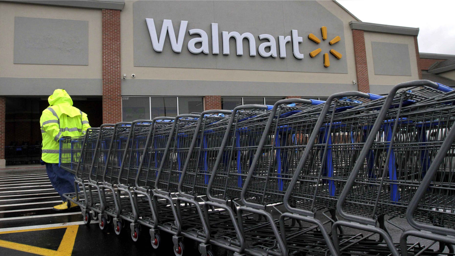 Worker pulls a line of shopping carts toward a Wal-Mart store in North Kingstown, R.I.