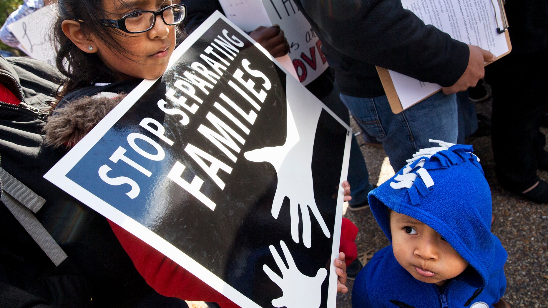 US citizens Esmeralda Tepetate, 10, with her brother Sebastian, 2, whose parents are originally from Mexico, holds a sign that says "stop separating families" during a rally for comprehensive immigration reform, Friday, Nov. 7, 2014, outside of the White House in Washington. After the midterm elections immigration groups are pushing for executive action. (AP Photo/Jacquelyn Martin)