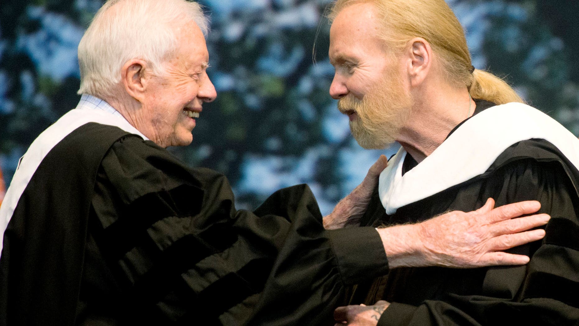 Jimmy Carter hugs Gregg Allman who received an honorary degree at Mercer University in Macon, Ga.