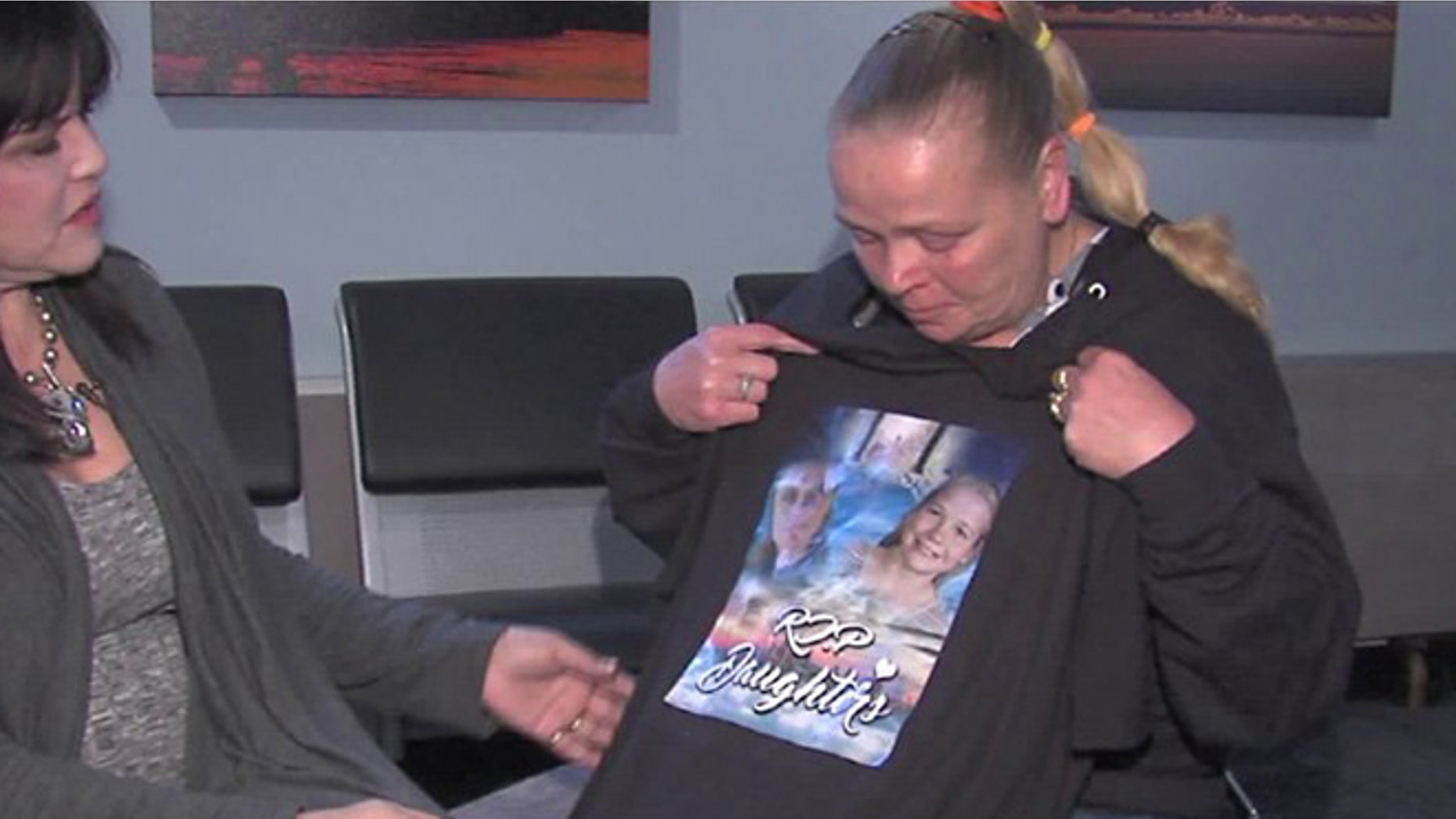 Cherri West holds up a tee-shirt that shows her two murdered daughters, Casey Eaton and 10-year-old Pamela Butler, with the phrase, "R.I.P Daughters."