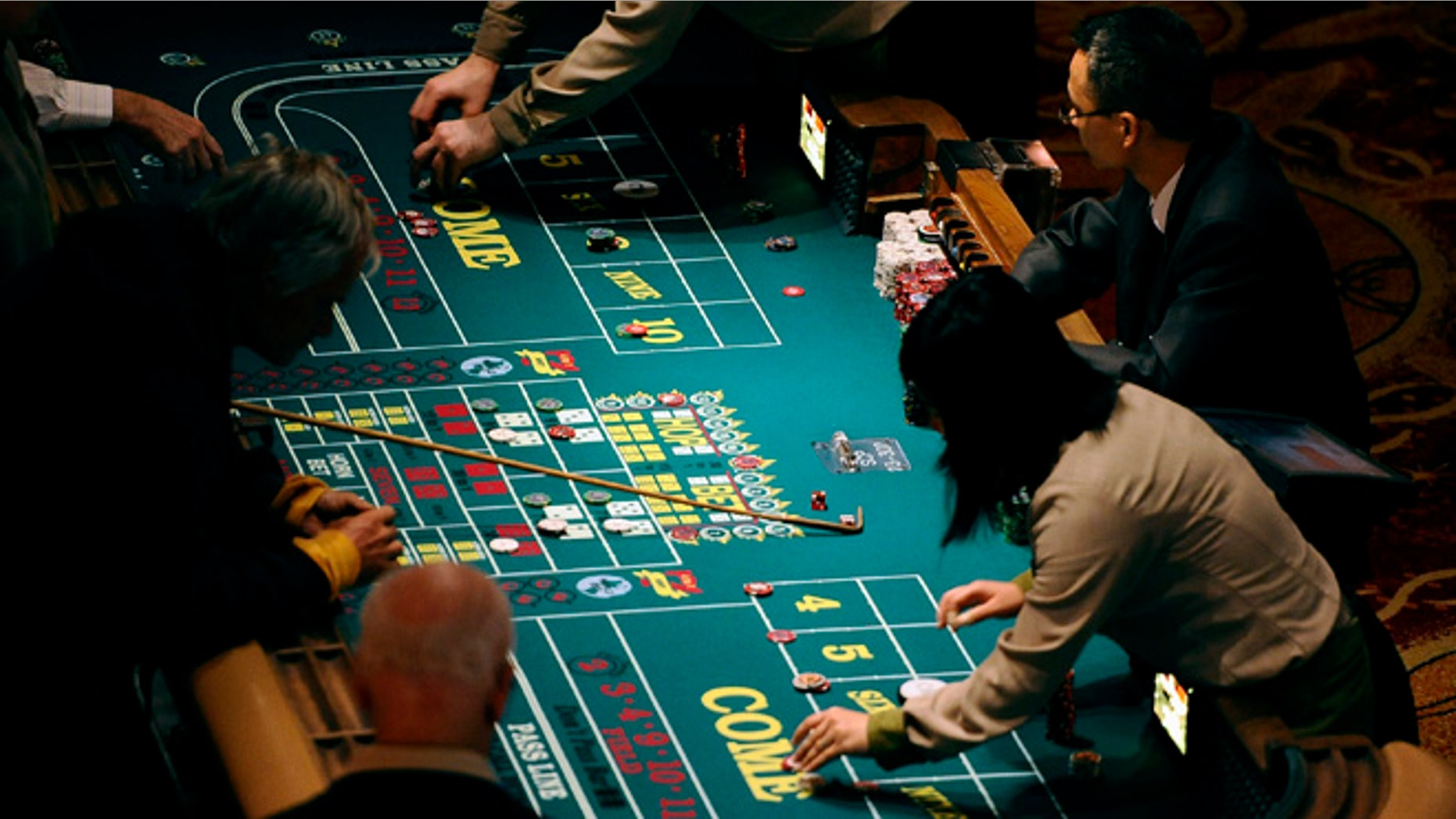 Sept. 18, 2013: In this photo, patrons play craps at a table at Mohegan Sun in Uncasville, Conn. As table games spread across the Northeast, resorts are using their own intelligence network more than ever to stay ahead of suspect players -- professional thieves as well as card counters -- who can easily hit multiple casinos in the span of a few days.