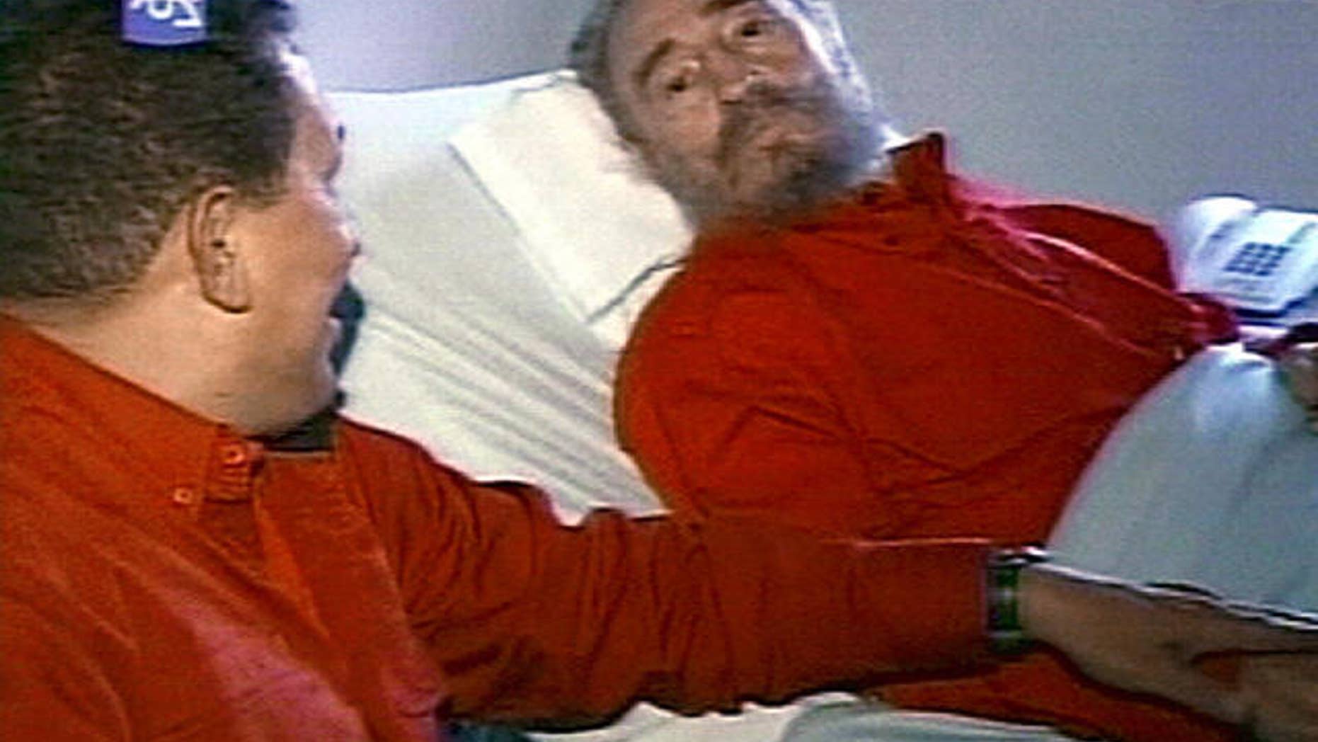 Former Cuban leader Fidel Castro, shown here in 2006 in a hospital bed, speaking with Venezuelan President Hugo Chavez.