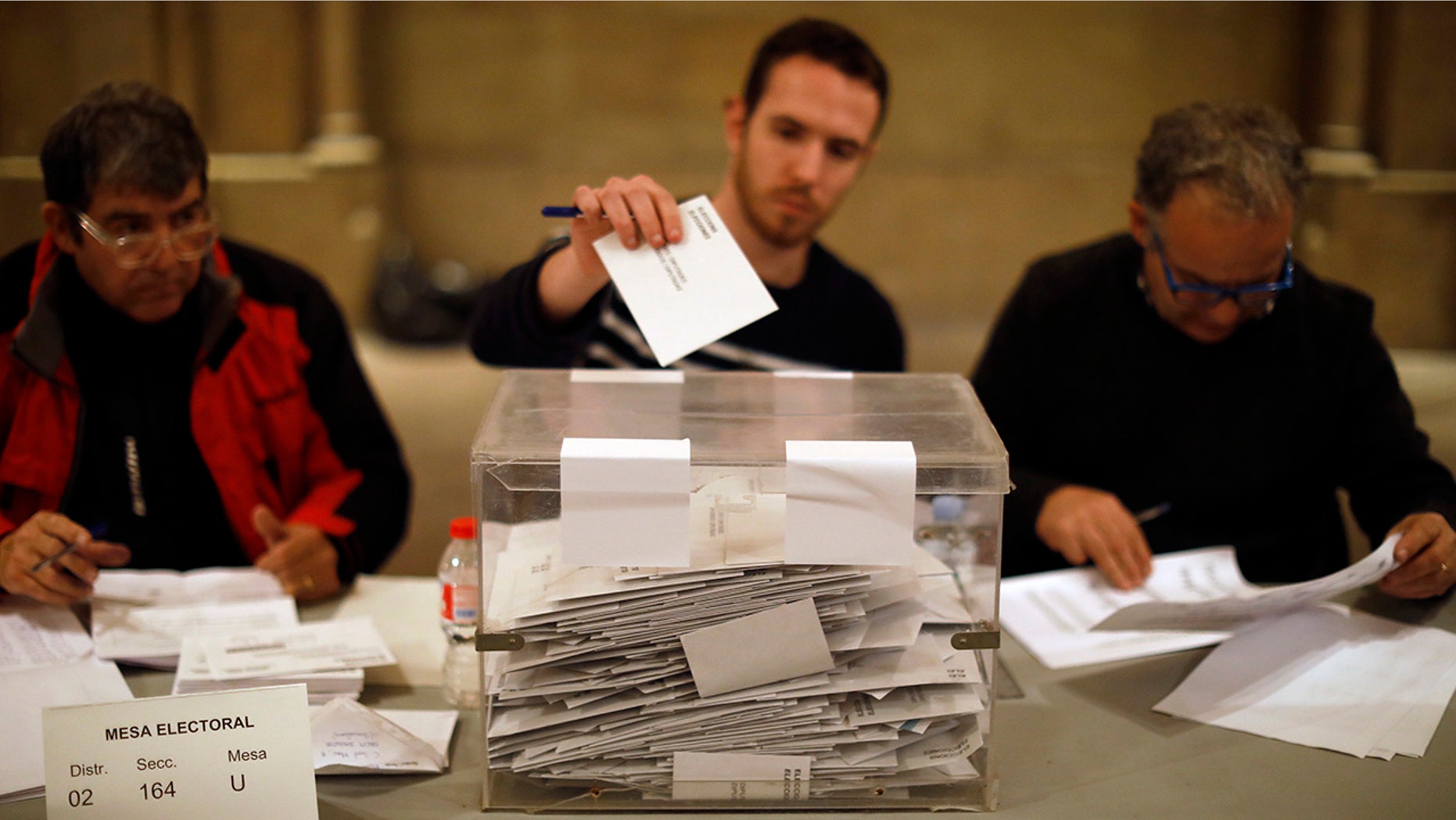As polls close, election workers cast their own ballots for the Catalan regional election in a polling station at the Barcelona University in Barcelona, Spain, on Thursday, Dec. 21, 2017.