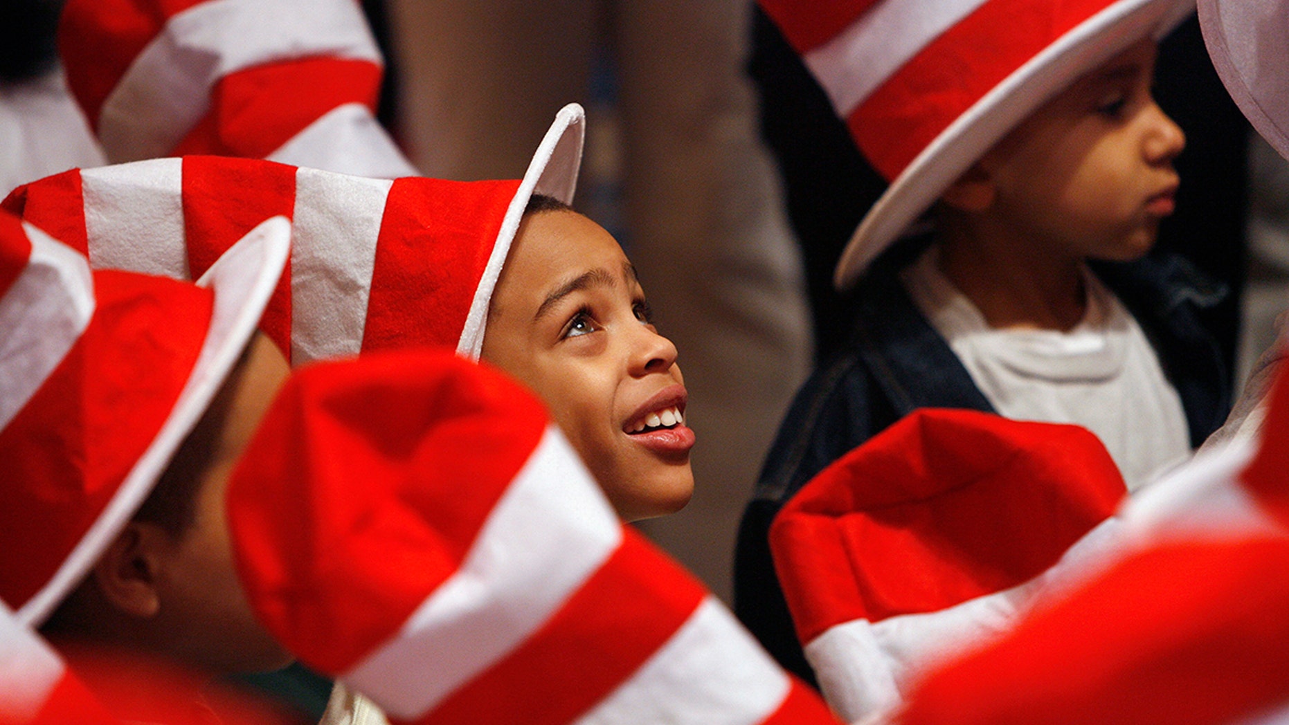 Children listen to tennis star Serena Williams read Dr. Seuss books to children during "Read Across America Day" to commemorate the 50th birthday of the "Cat In The Hat" character at the New York Public Library in New York, March 2, 2007. Recently, the Dr. Seuss museum in Massachusetts agreed to remove a mural after complaints of racism.