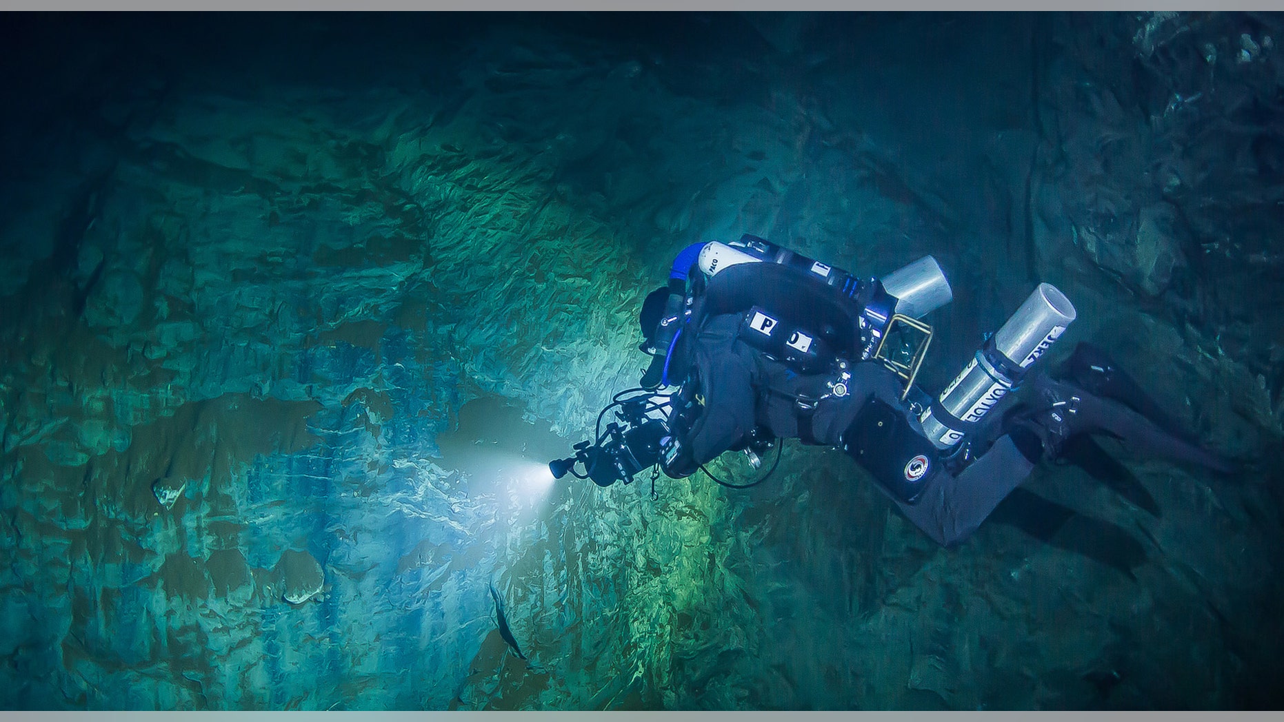 In this underwater photo taken Aug. 15, 2015 in the flooded Hranicka Propast, or Hranice Abyss, in the Czech Republic Polish explorer Slawomir Packo is exploring the limestone abyss and preparing for deeper exploration with the use of a remotely-operated underwater robot, or ROV. (Krzysztof Starnawski of EXPEDITION via AP)
